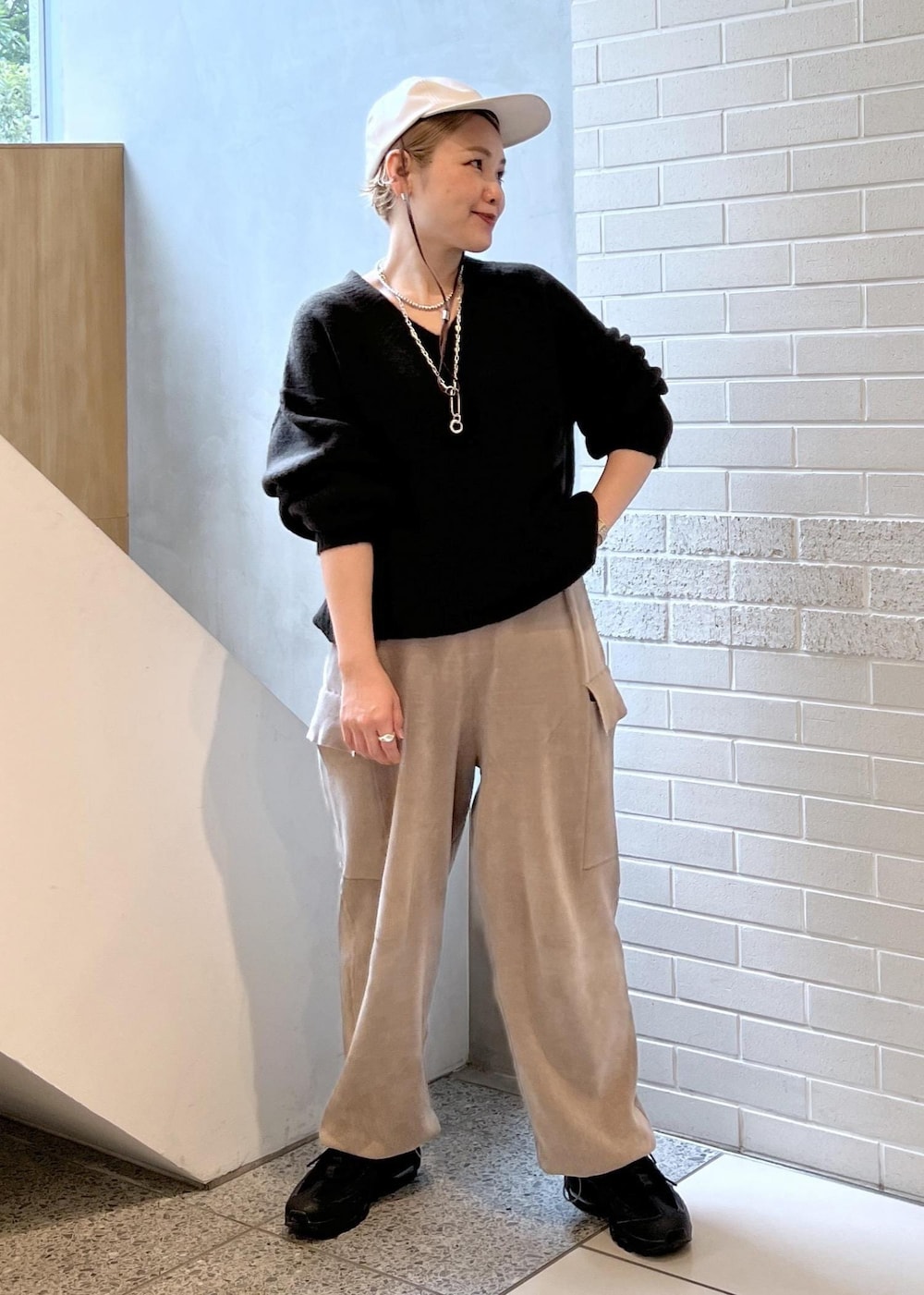 ホワイト系のピーコート、グレー系のカーゴパンツ、ブラウン系のニット/セーターを着用したレディースの秋コーディネートの8枚目の写真