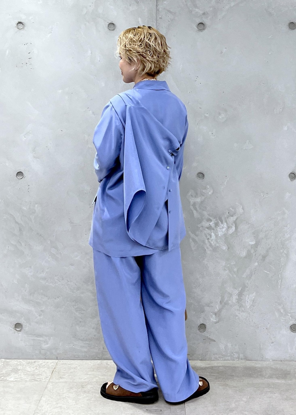 ブラウン系のショルダーバッグ、ブラウン系のサンダル、ブルー系のテーラードジャケットを着用したレディースの冬コーディネートの8枚目の写真