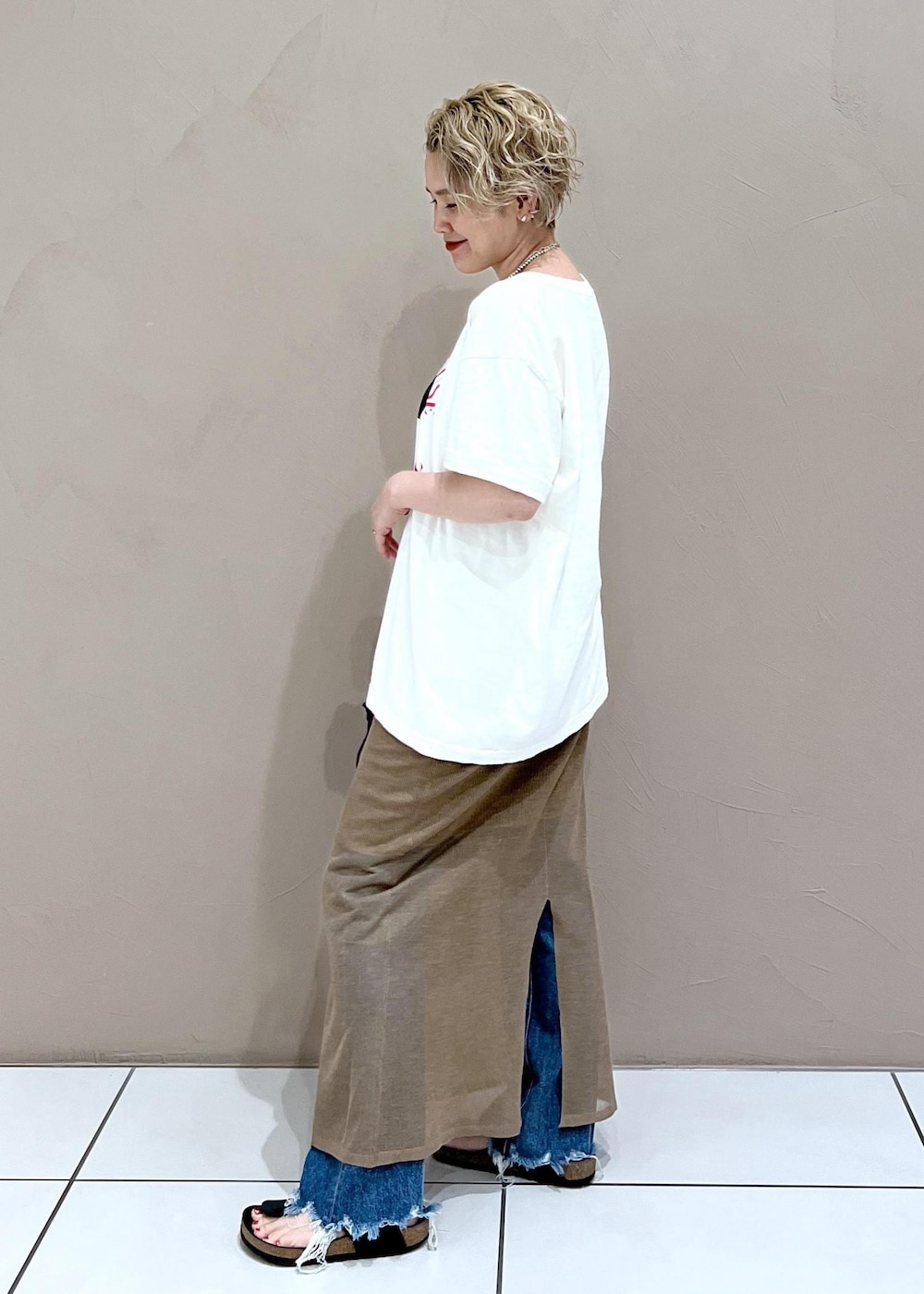 ブラック系のショルダーバッグ、ホワイト系のTシャツ/カットソー、ブルー系のデニムパンツを着用したレディースの夏コーディネートの6枚目の写真