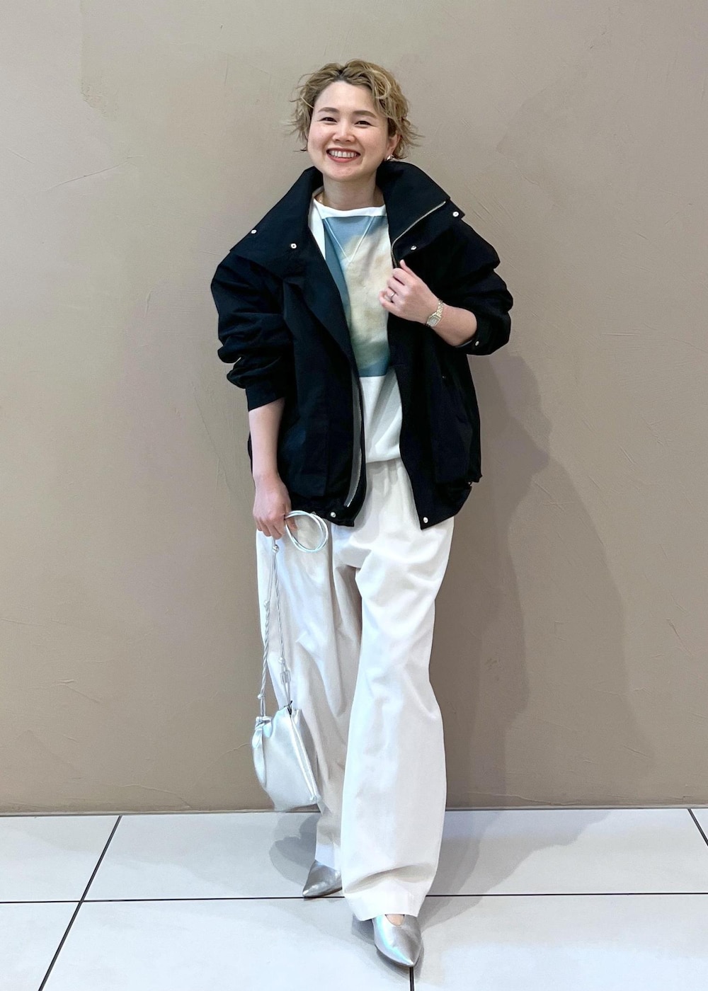 ブラック系のブルゾン、ホワイト系のその他パンツ、シルバー系のショルダーバッグを着用したレディースの春コーディネートの2枚目の写真