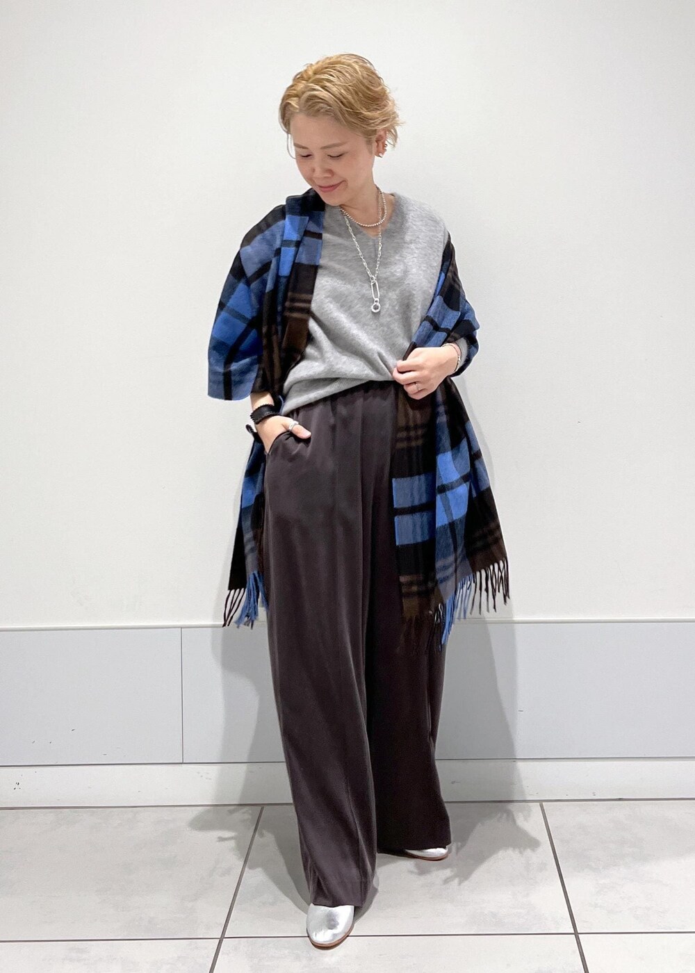 グレー系のその他パンツ、シルバー系のパンプス、その他のネックレスを着用したレディースの秋コーディネートの3枚目の写真