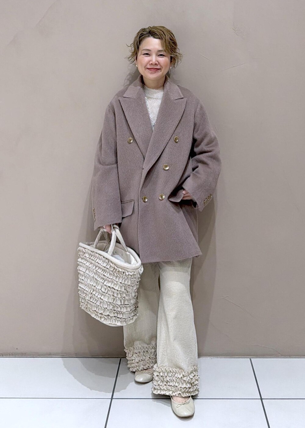 ベージュ系のパンプス、ブラウン系のチェスターコートを着用したレディースの冬コーディネートの3枚目の写真