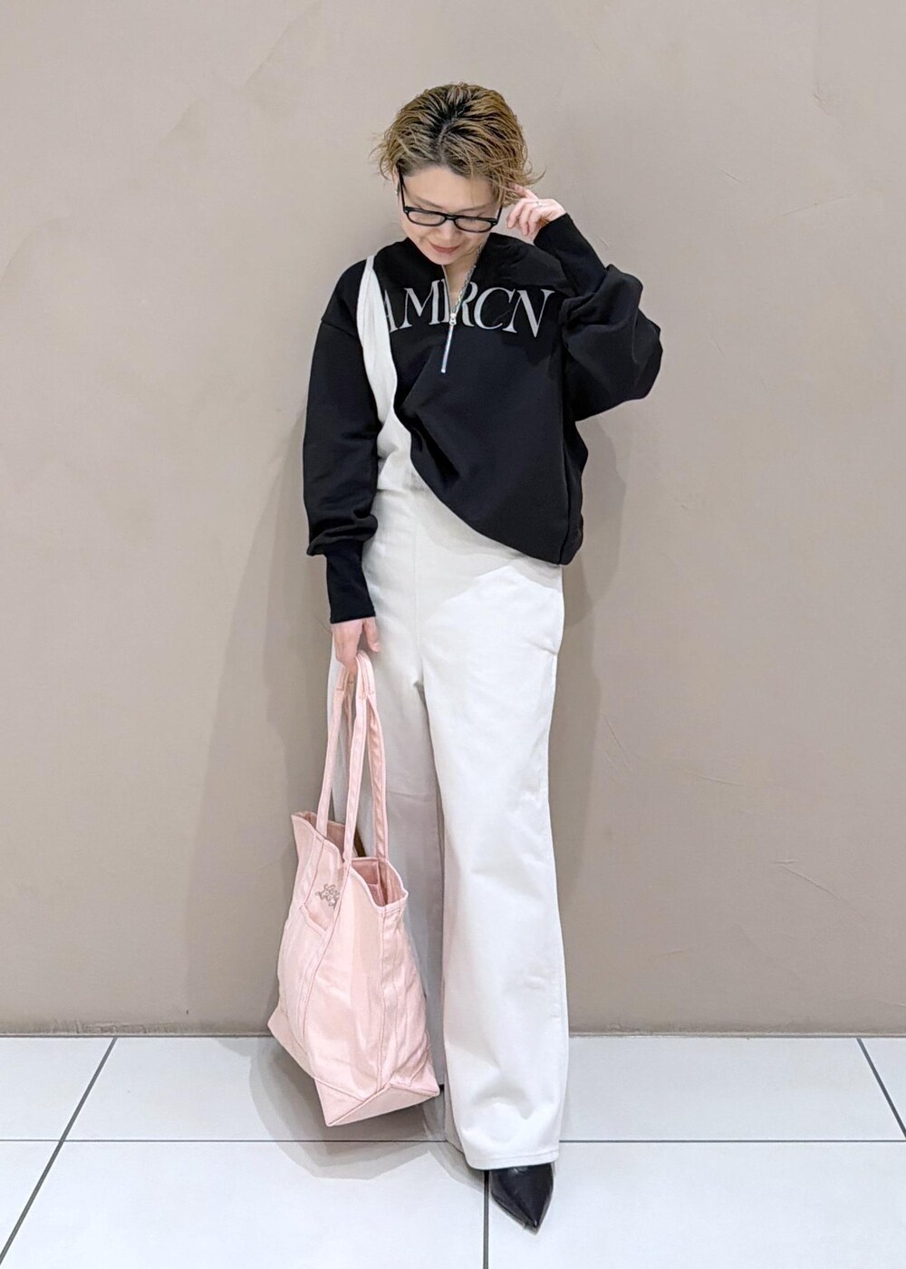 ブラック系のパンプス、ホワイト系のサロペット/オーバーオール、ブラック系のスウェットを着用したレディースの冬コーディネートの3枚目の写真