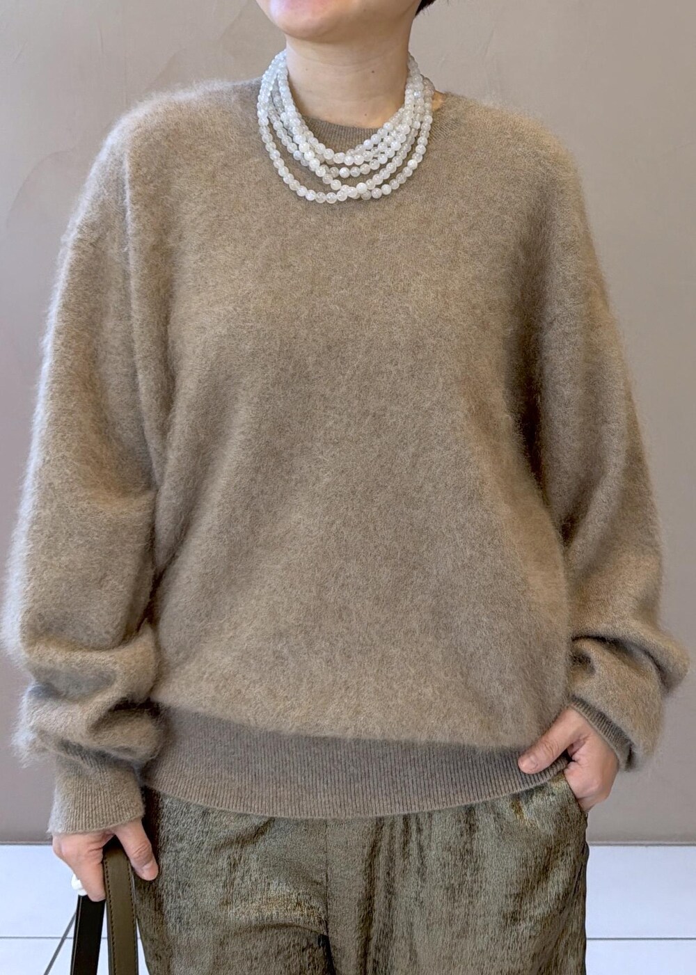 ゴールド系のその他パンツ、ベージュ系のニット/セーター、グリーン系のパンプスを着用したレディースの冬コーディネートの7枚目の写真