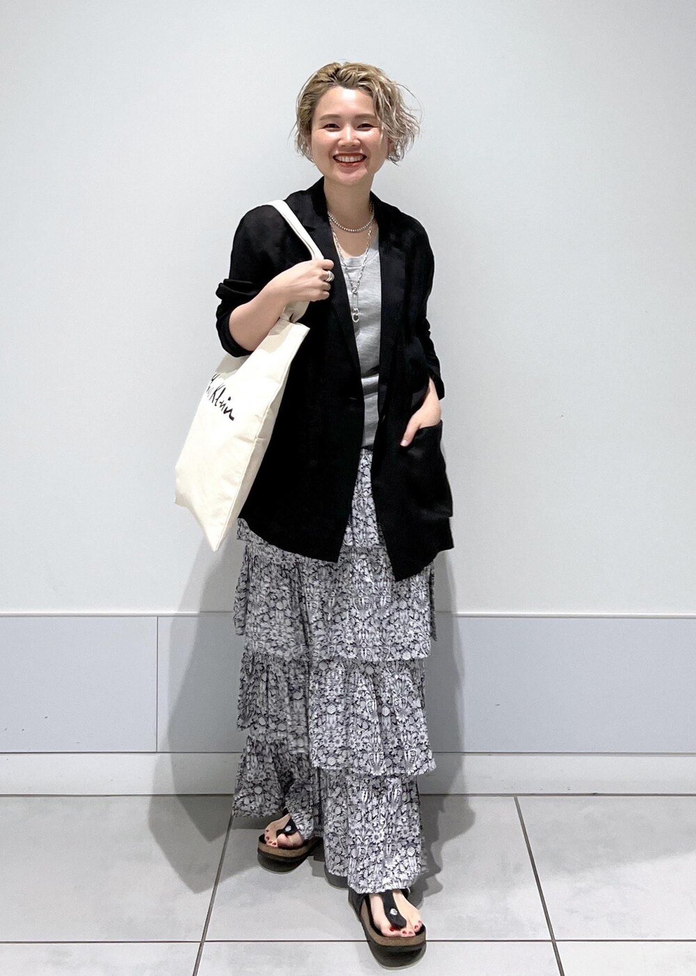 ブラック系のテーラードジャケット、ブラック系のスカートを着用したレディースの夏コーディネートの4枚目の写真