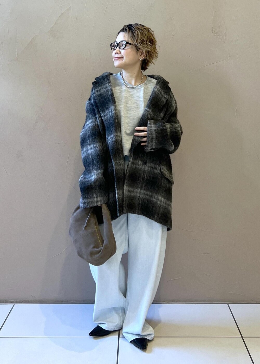 ブルー系のデニムパンツ、グレー系のその他アウター、グレー系のハンドバッグを着用したレディースの秋コーディネートの2枚目の写真