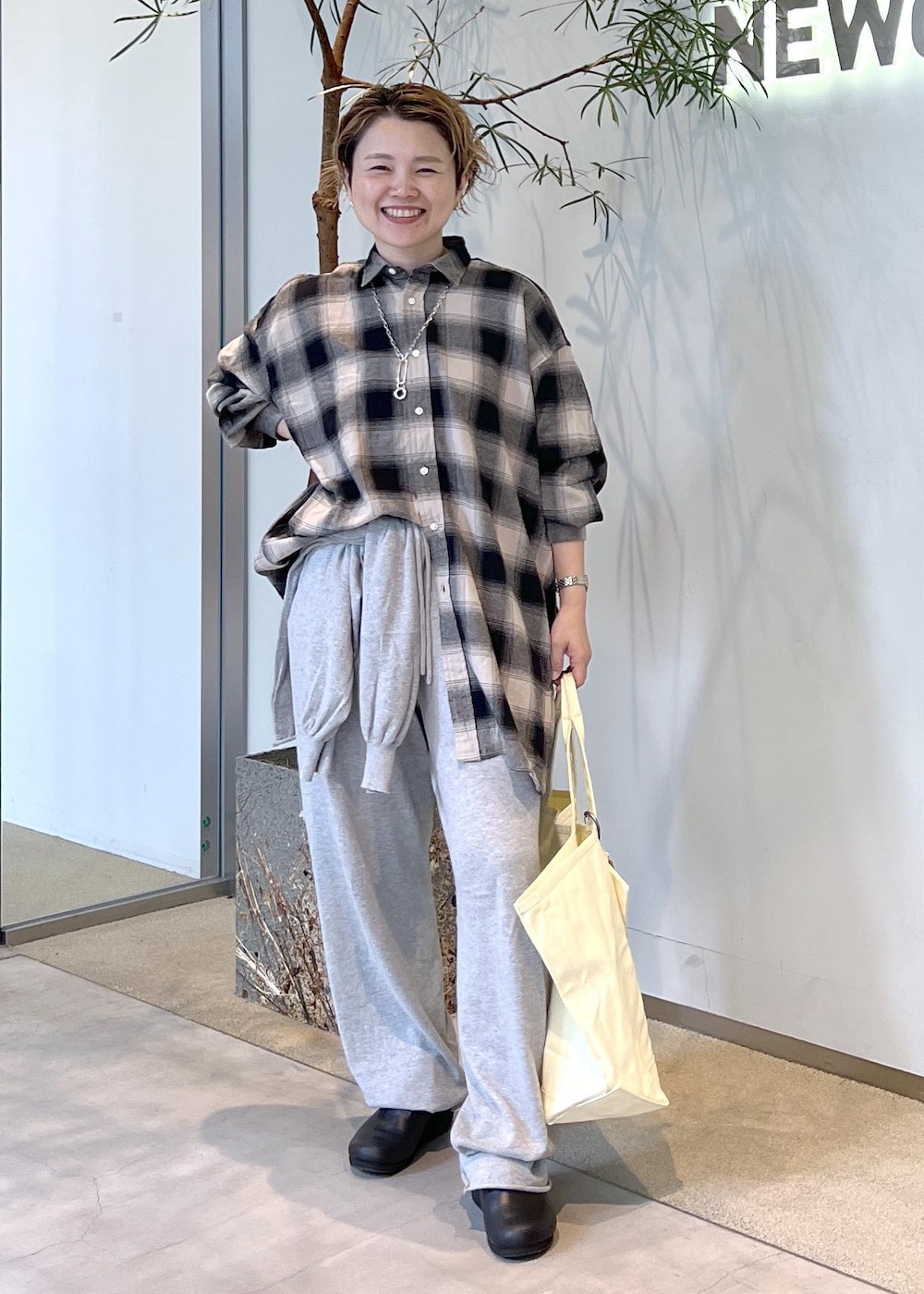 ブラック系のスニーカー、イエロー系のトートバッグを着用したレディースの秋コーディネートの5枚目の写真