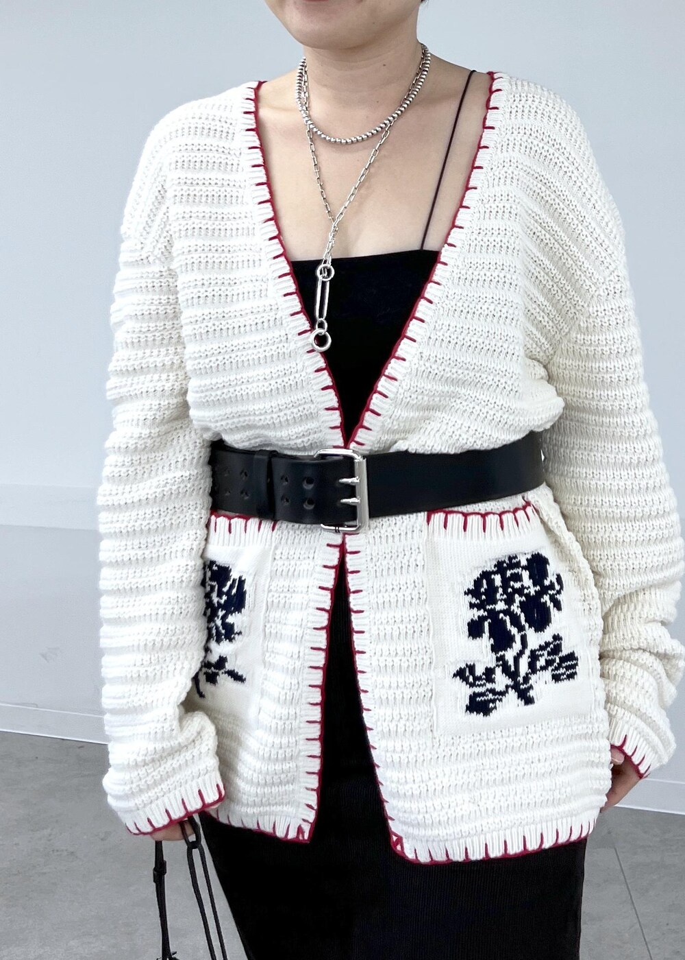 グレー系のスカート、ホワイト系のニット/セーター、レッド系のブーツを着用したレディースの秋コーディネートの7枚目の写真