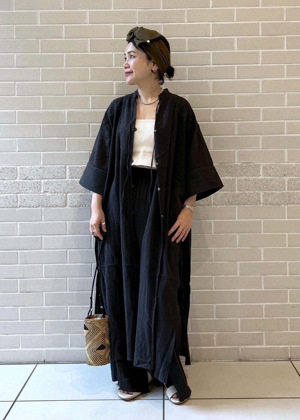 ホワイト系のチューブトップ、ベージュ系のサンダル、ブラック系のシャツ/ブラウスを着用したレディースの夏コーディネートの3枚目の写真