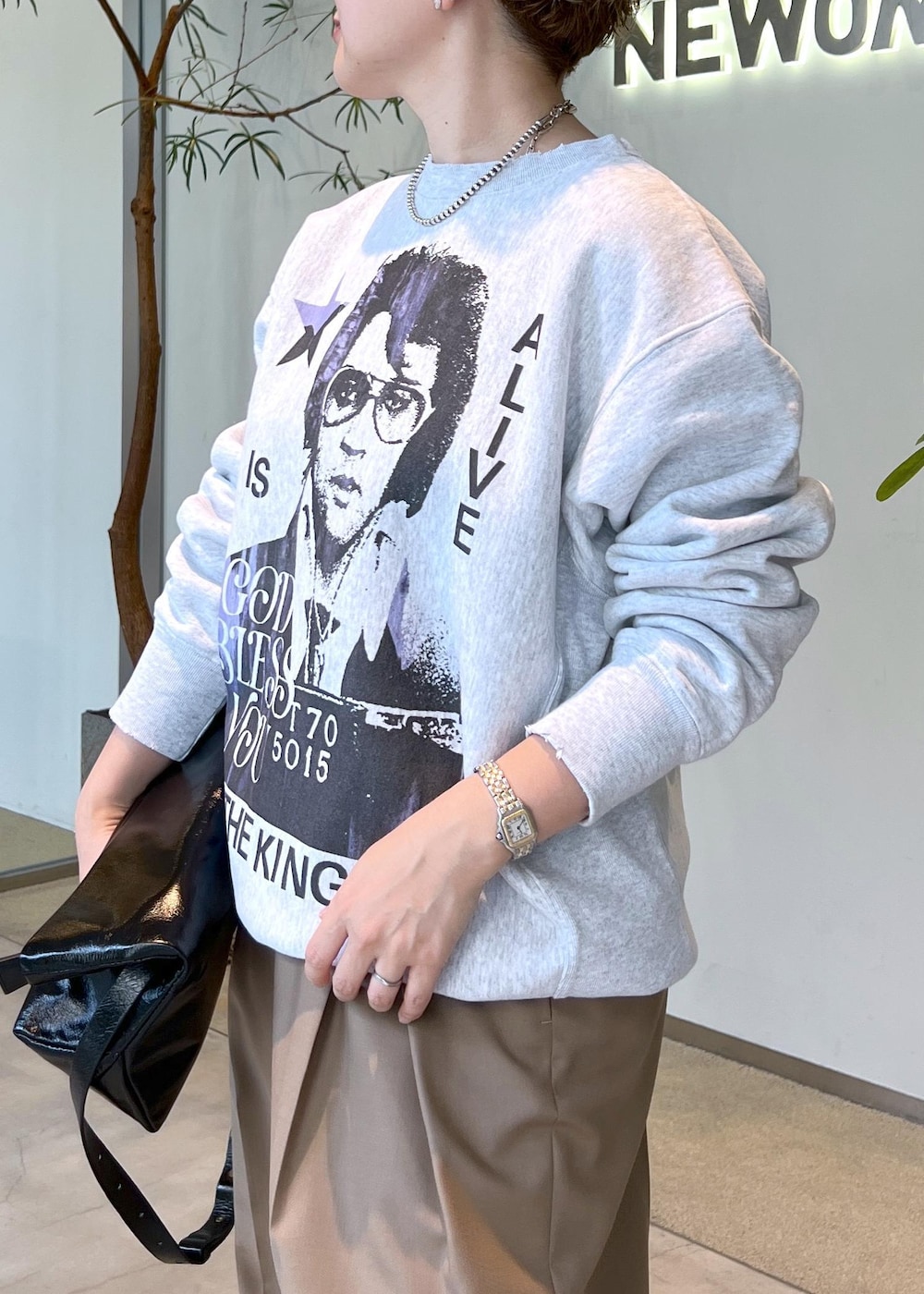 ベージュ系のスラックス、ブラック系のショルダーバッグ、ブラック系のスニーカーを着用したレディースの秋コーディネートの6枚目の写真