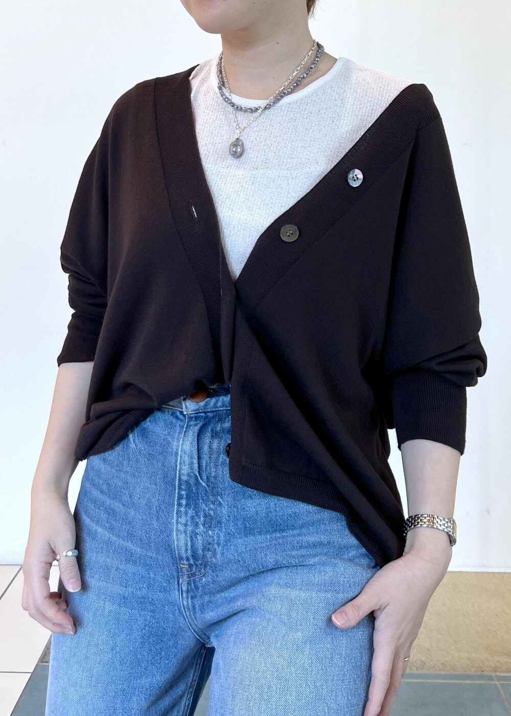 ブラック系のサンダル、ブラウン系のカーディガン/ボレロ、ブルー系のデニムパンツを着用したレディースの夏コーディネートの5枚目の写真