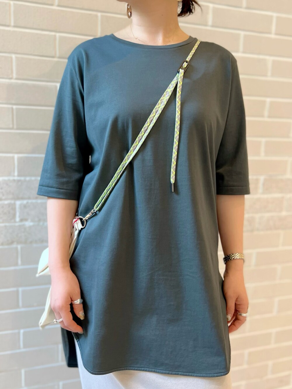 グリーン系のTシャツ/カットソー、ホワイト系のエコバッグ/サブバッグ、グレー系のスカートを着用したレディースの夏コーディネートの4枚目の写真