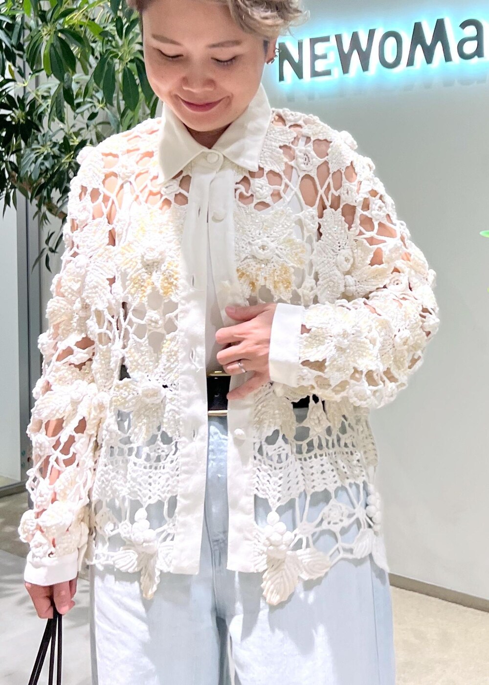 ブルー系のデニムパンツ、ブラウン系のハンドバッグを着用したレディースの夏コーディネートの8枚目の写真