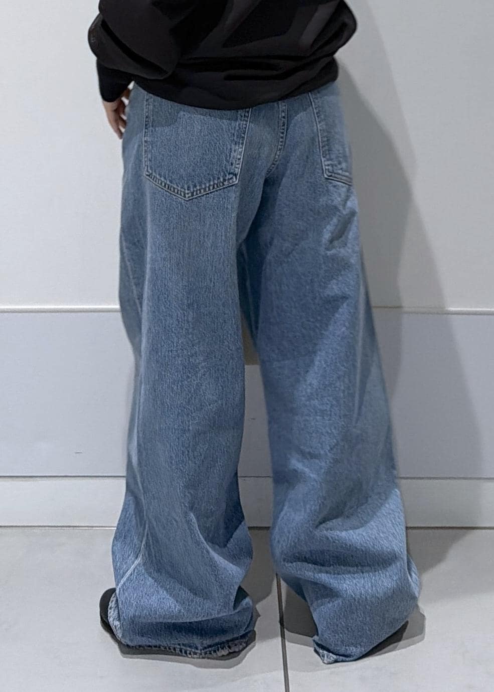 ブラック系のスウェット、ブルー系のデニムパンツを着用したレディースの冬コーディネートの8枚目の写真