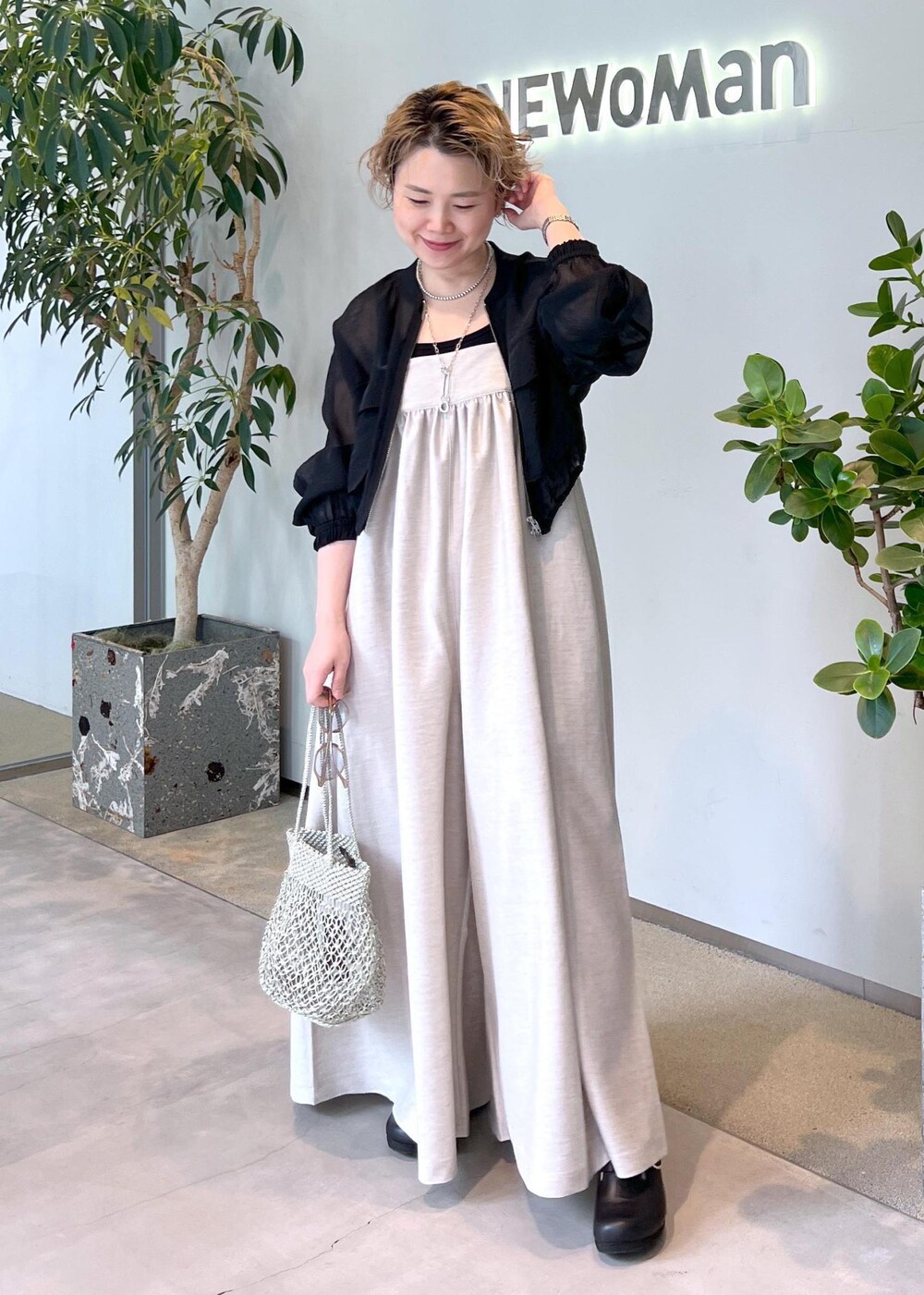 ブラック系のブルゾン、ブラック系のタンクトップ、シルバー系のトートバッグを着用したレディースの春コーディネートの2枚目の写真