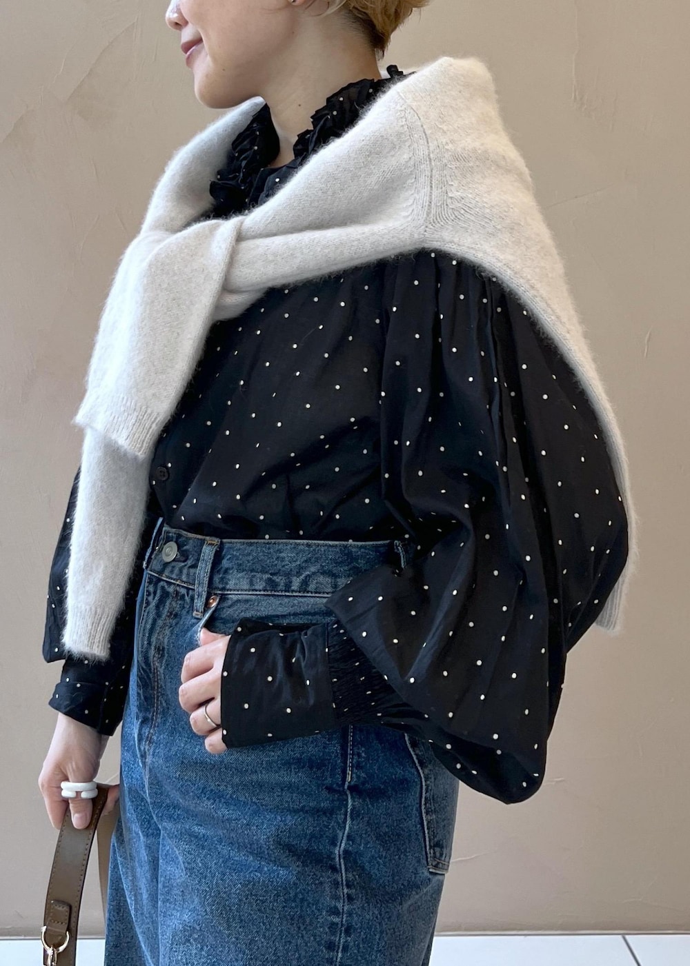 グレー系のニット/セーター、ブルー系のデニムパンツ、ブラウン系のショルダーバッグを着用したレディースの秋コーディネートの8枚目の写真