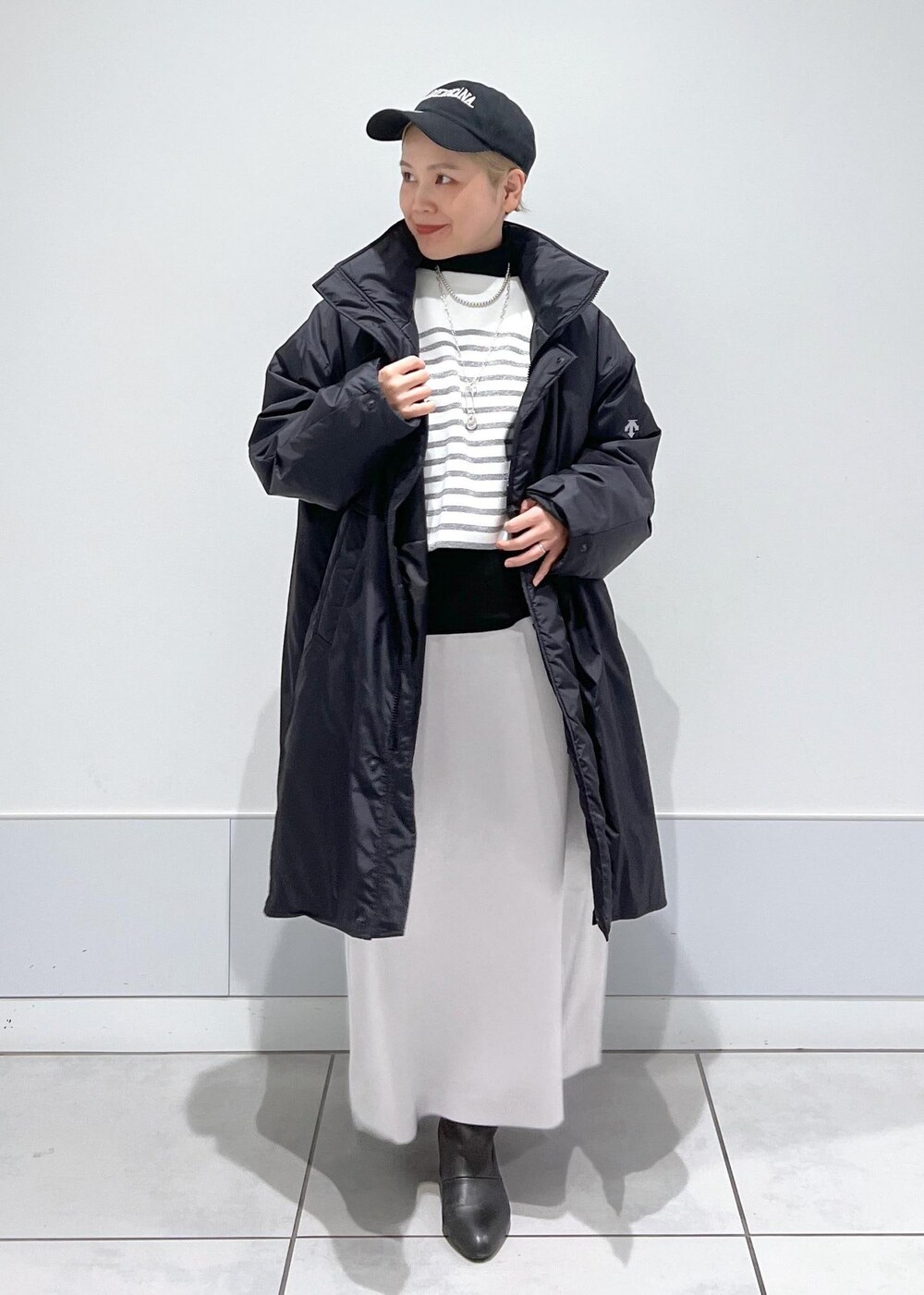 ブラック系のブーツ、ブラック系のTシャツ/カットソー、ブラック系のトートバッグを着用したレディースの冬コーディネートの2枚目の写真