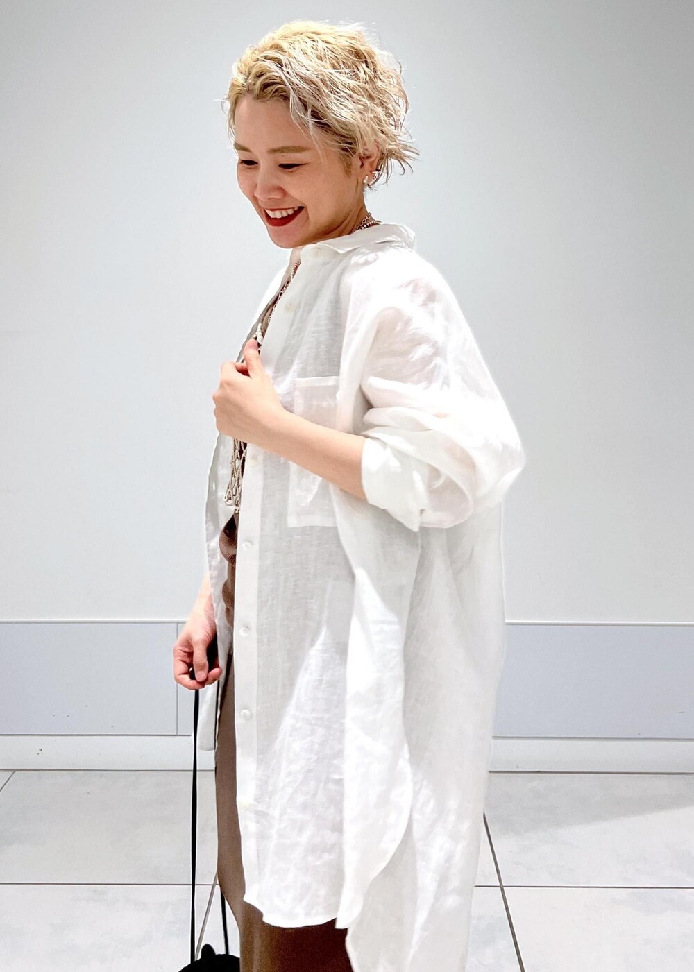 ブラック系のショルダーバッグ、ベージュ系のキャミソール、ブラウン系のタンクトップを着用したレディースの夏コーディネートの8枚目の写真