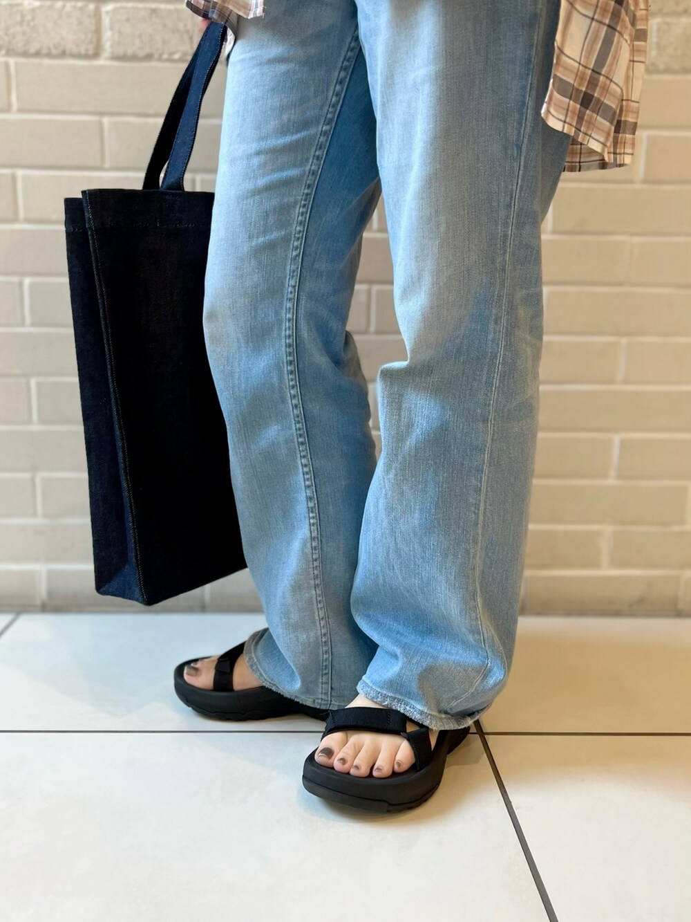 オレンジ系のシャツ/ブラウス、ブルー系のデニムパンツ、ブルー系のトートバッグを着用したレディースの夏コーディネートの4枚目の写真