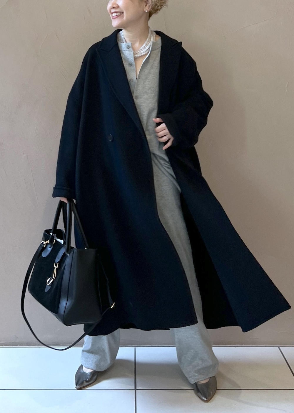 ブラック系のハンドバッグ、ブラック系のその他アウター、シルバー系のパンプスを着用したレディースの秋コーディネートの10枚目の写真