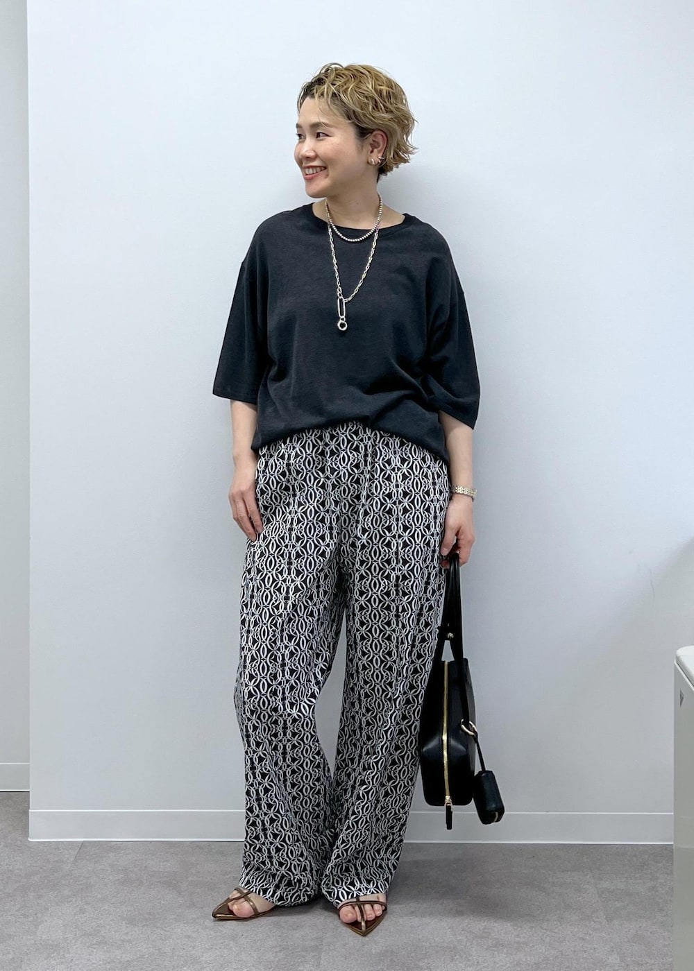 グレー系のTシャツ/カットソー、その他のサンダル、ブラック系のショルダーバッグを着用したレディースの春コーディネートの3枚目の写真