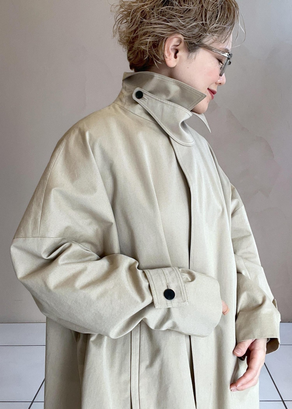 ホワイト系のニット/セーター、ベージュ系のステンカラーコート、ホワイト系のその他パンツを着用したレディースの冬コーディネートの3枚目の写真