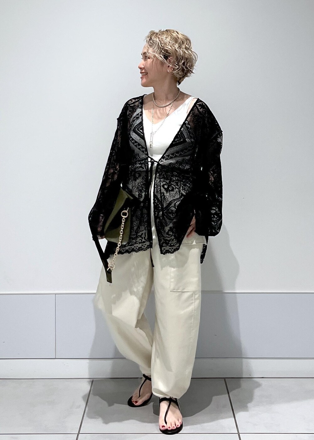ホワイト系のカーゴパンツ、ホワイト系のキャミソール、ブラック系のノーカラージャケットを着用したレディースの夏コーディネートの3枚目の写真