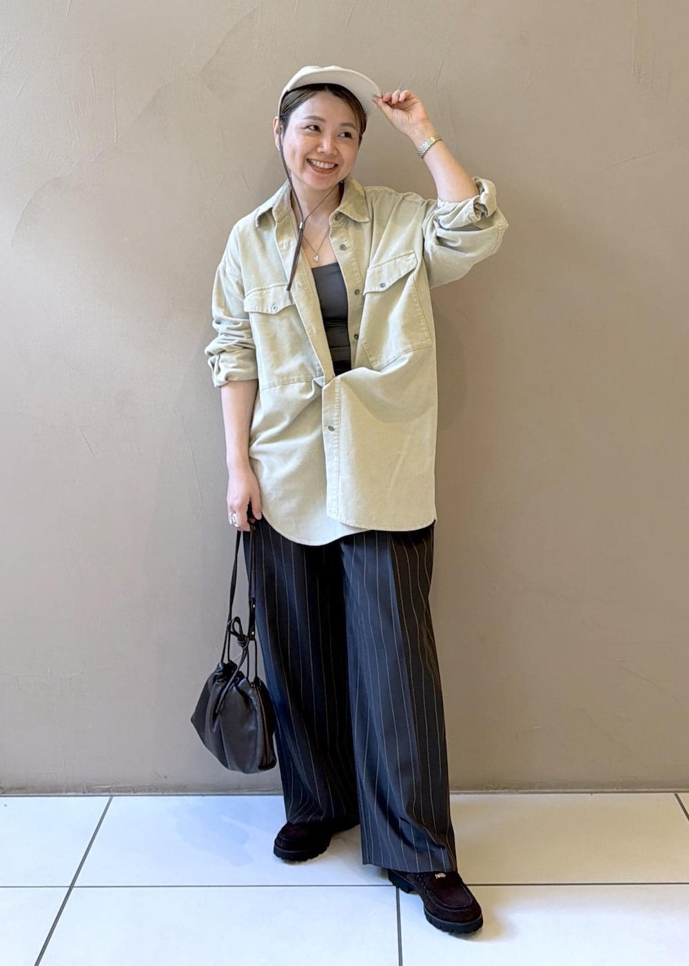 グレー系のその他パンツ、ブラウン系のショルダーバッグ、ブラウン系のローファーを着用したレディースの夏コーディネートの3枚目の写真