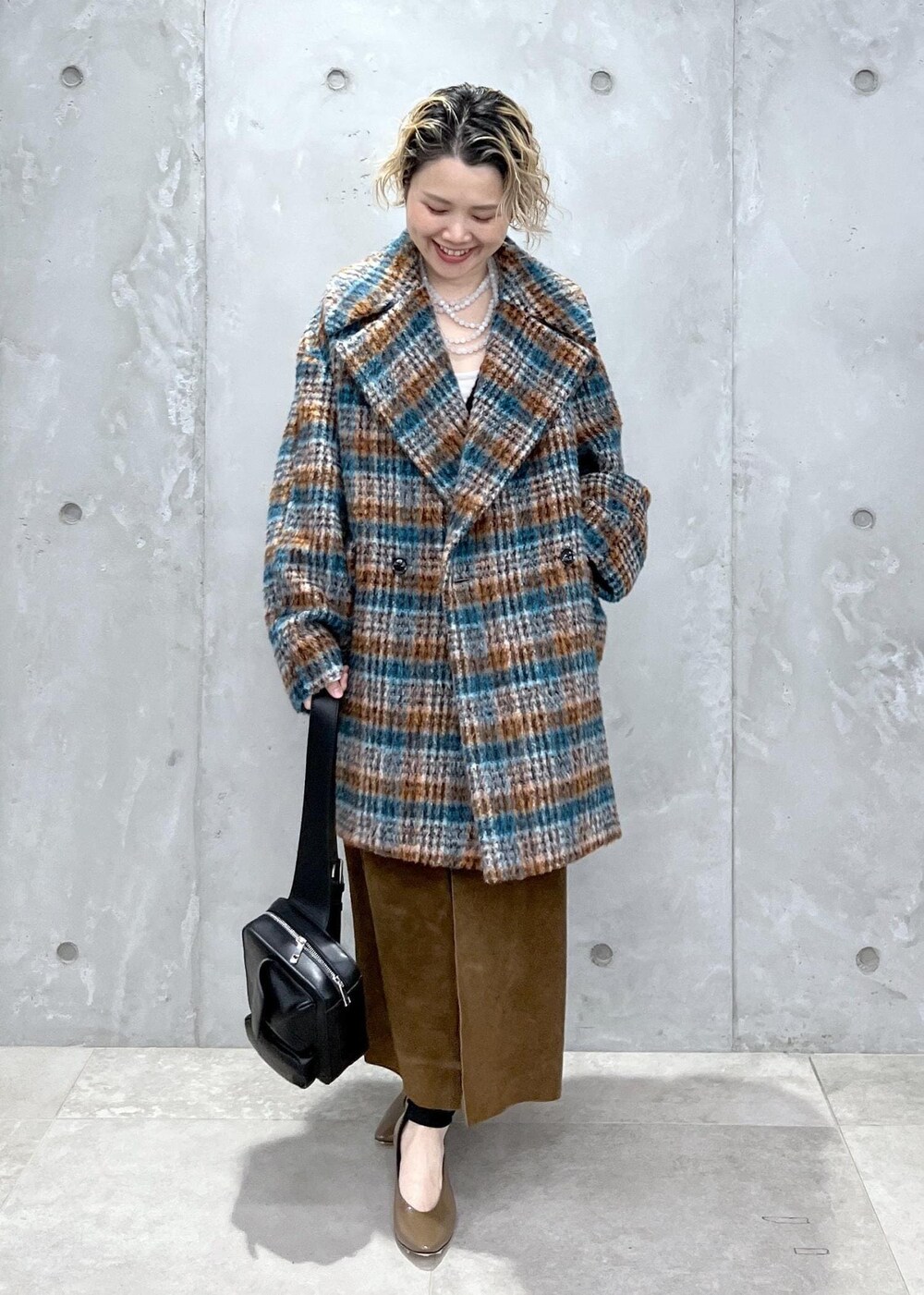 ブラック系のベスト、ブルー系のピーコート、ブラック系のボディバッグ/ウエストポーチを着用したレディースの秋コーディネートの4枚目の写真