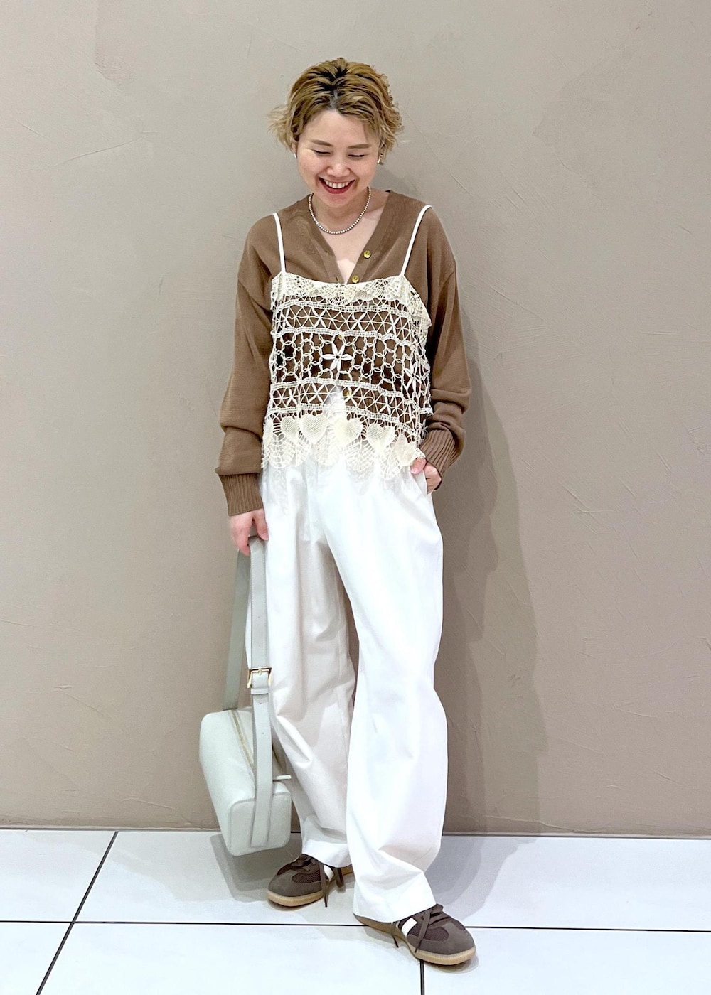 グレー系のショルダーバッグ、ホワイト系のその他パンツ、イエロー系のカーディガン/ボレロを着用したレディースの春コーディネートの3枚目の写真