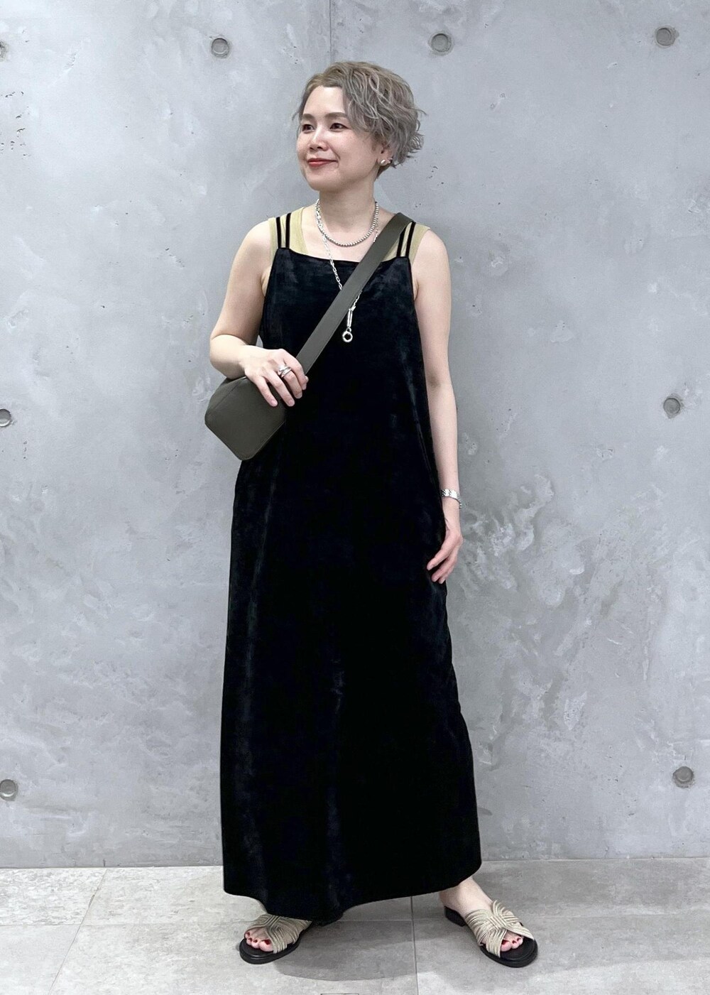 グリーン系のショルダーバッグ、イエロー系のタンクトップ、ブラック系のワンピースを着用したレディースの夏コーディネートの2枚目の写真