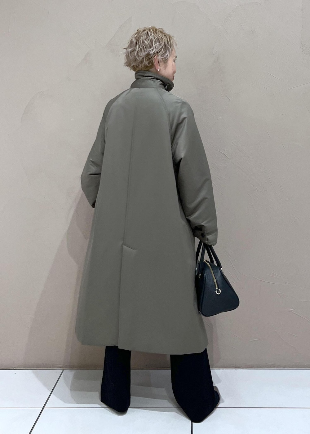 ブラック系のボストンバッグ、グリーン系のダウンジャケット/コート、ブラック系のその他パンツを着用したレディースの秋コーディネートの6枚目の写真