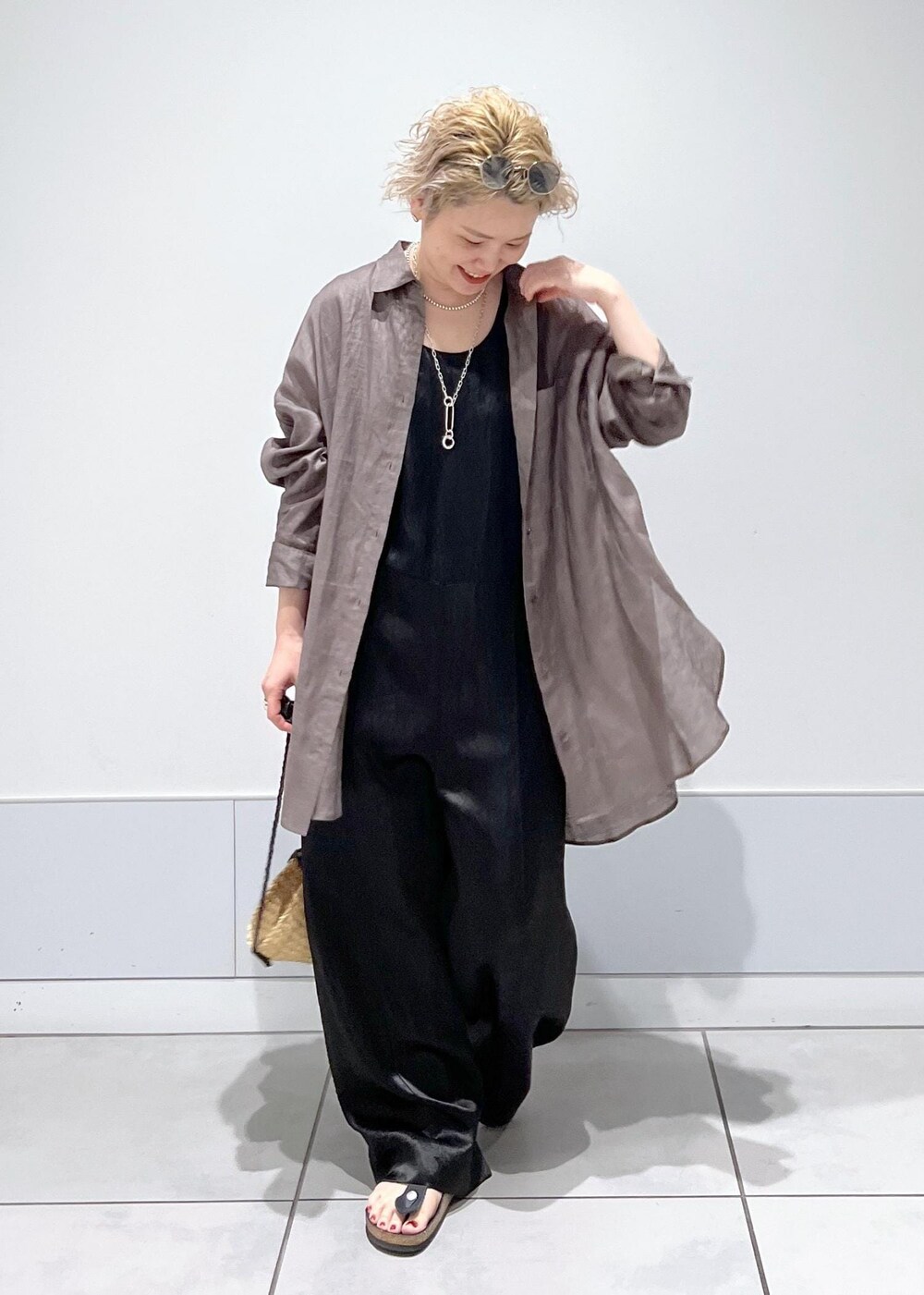 ベージュ系のかごバッグ、グレー系のシャツ/ブラウス、ブラック系のつなぎ/オールインワンを着用したレディースの夏コーディネートの3枚目の写真