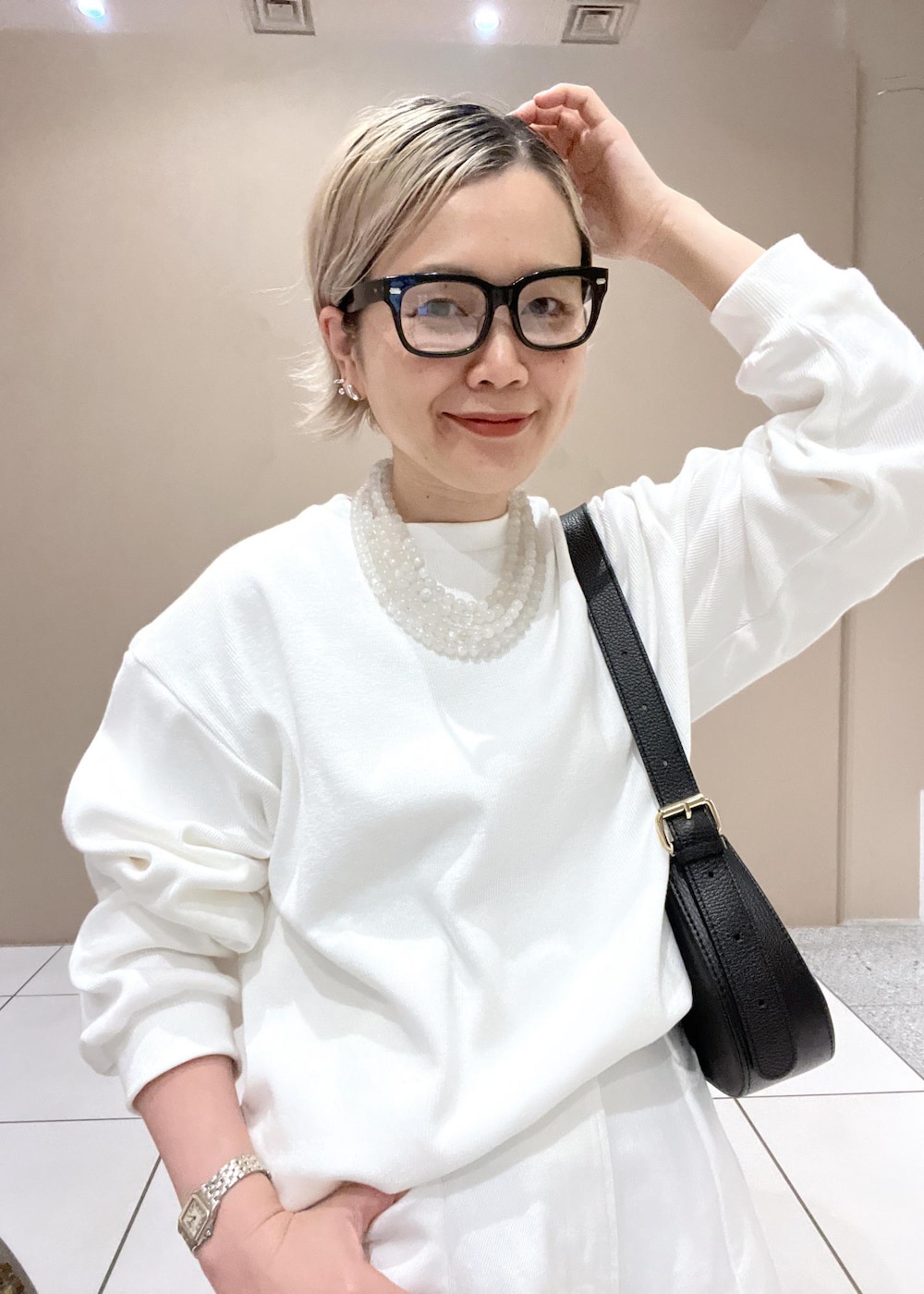 ホワイト系のデニムパンツ、ブラック系のショルダーバッグを着用したレディースの夏コーディネートの7枚目の写真