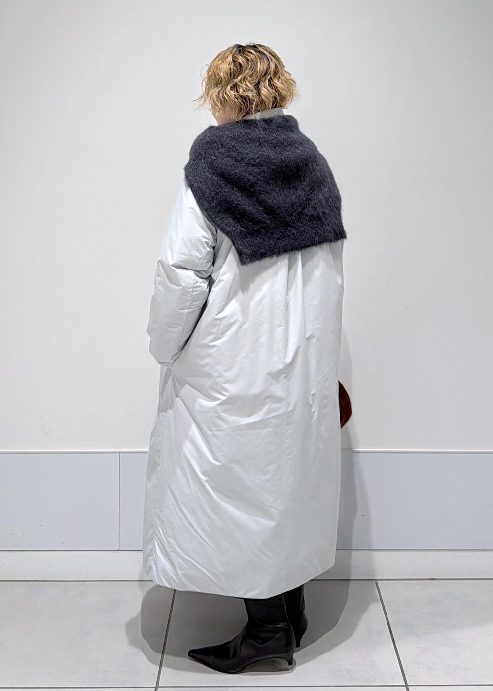 ブラック系のスカート、ブラウン系のハンドバッグ、グレー系のダウンジャケット/コートを着用したレディースの秋コーディネートの5枚目の写真