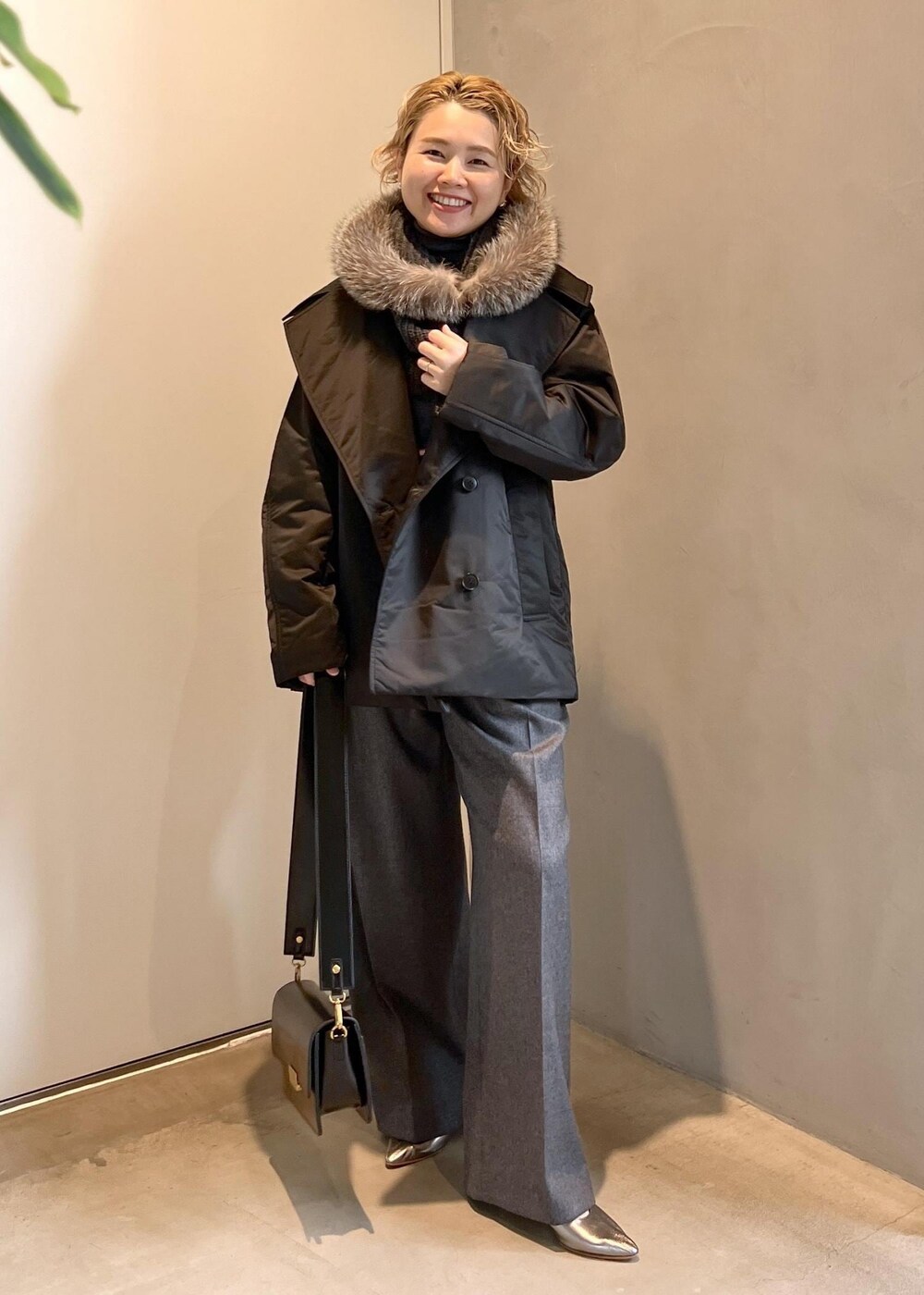 ブラック系のショルダーバッグ、グレー系のニット/セーター、グレー系のスラックスを着用したレディースの秋コーディネートの4枚目の写真