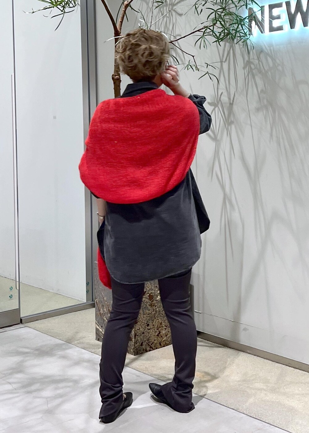 グレー系のシャツ/ブラウス、ブラック系のパンプス、レッド系のニット/セーターを着用したレディースの秋コーディネートの6枚目の写真