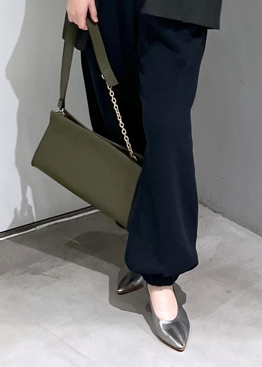 グリーン系のショルダーバッグ、ブラック系のスウェットパンツ、シルバー系のパンプスを着用したレディースの秋コーディネートの8枚目の写真