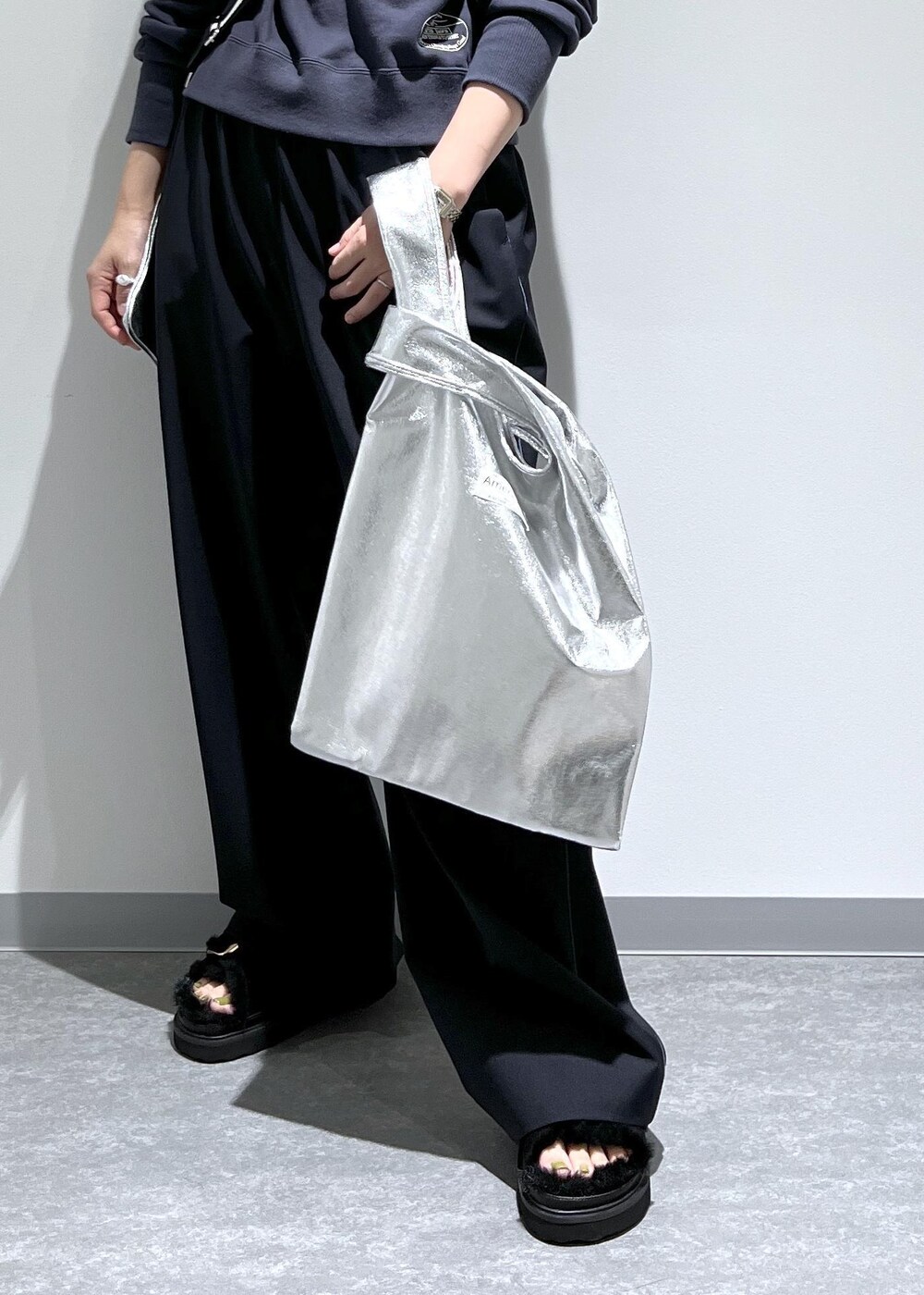 ブルー系のスラックス、グレー系のパーカー、シルバー系のトートバッグを着用したレディースの夏コーディネートの7枚目の写真