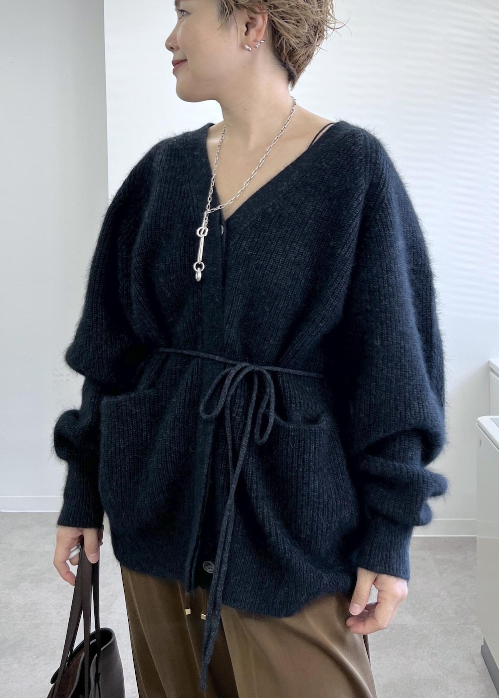 ブラック系のブーツ、ブラウン系のその他パンツ、グレー系のカーディガン/ボレロを着用したレディースの秋コーディネートの4枚目の写真