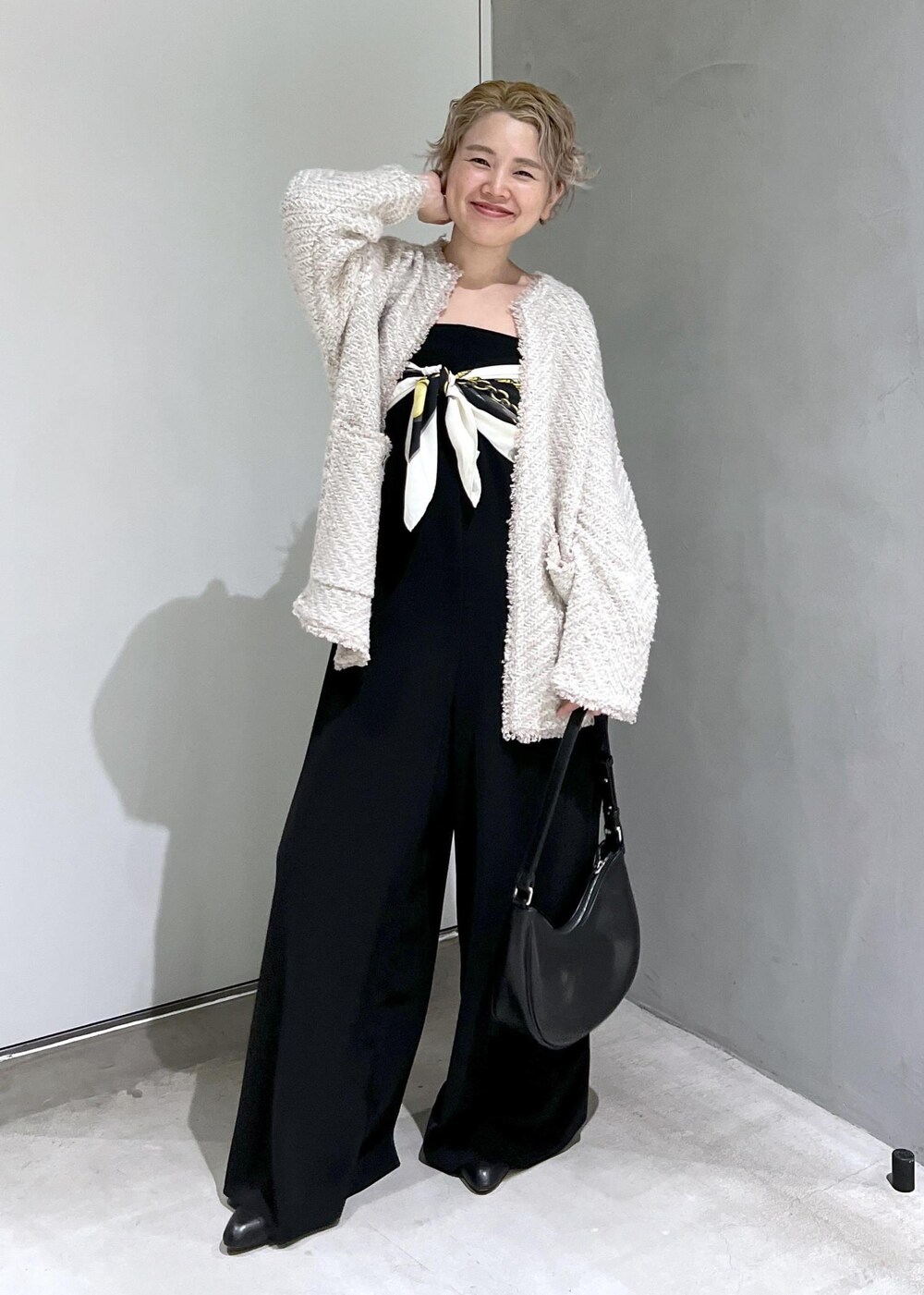 ブラック系のつなぎ/オールインワン、ベージュ系のカーディガン/ボレロ、ブラック系のブーツを着用したレディースの秋コーディネートの4枚目の写真