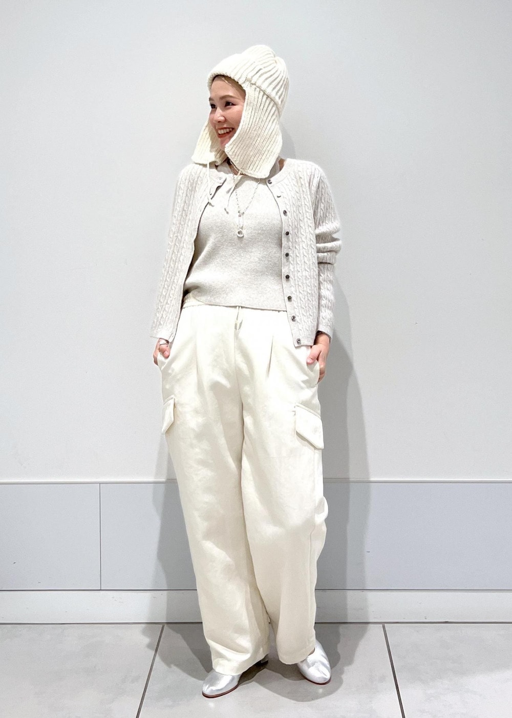 ホワイト系のカーゴパンツ、ホワイト系のキャミソール、ホワイト系のカーディガン/ボレロを着用したレディースの冬コーディネートの3枚目の写真