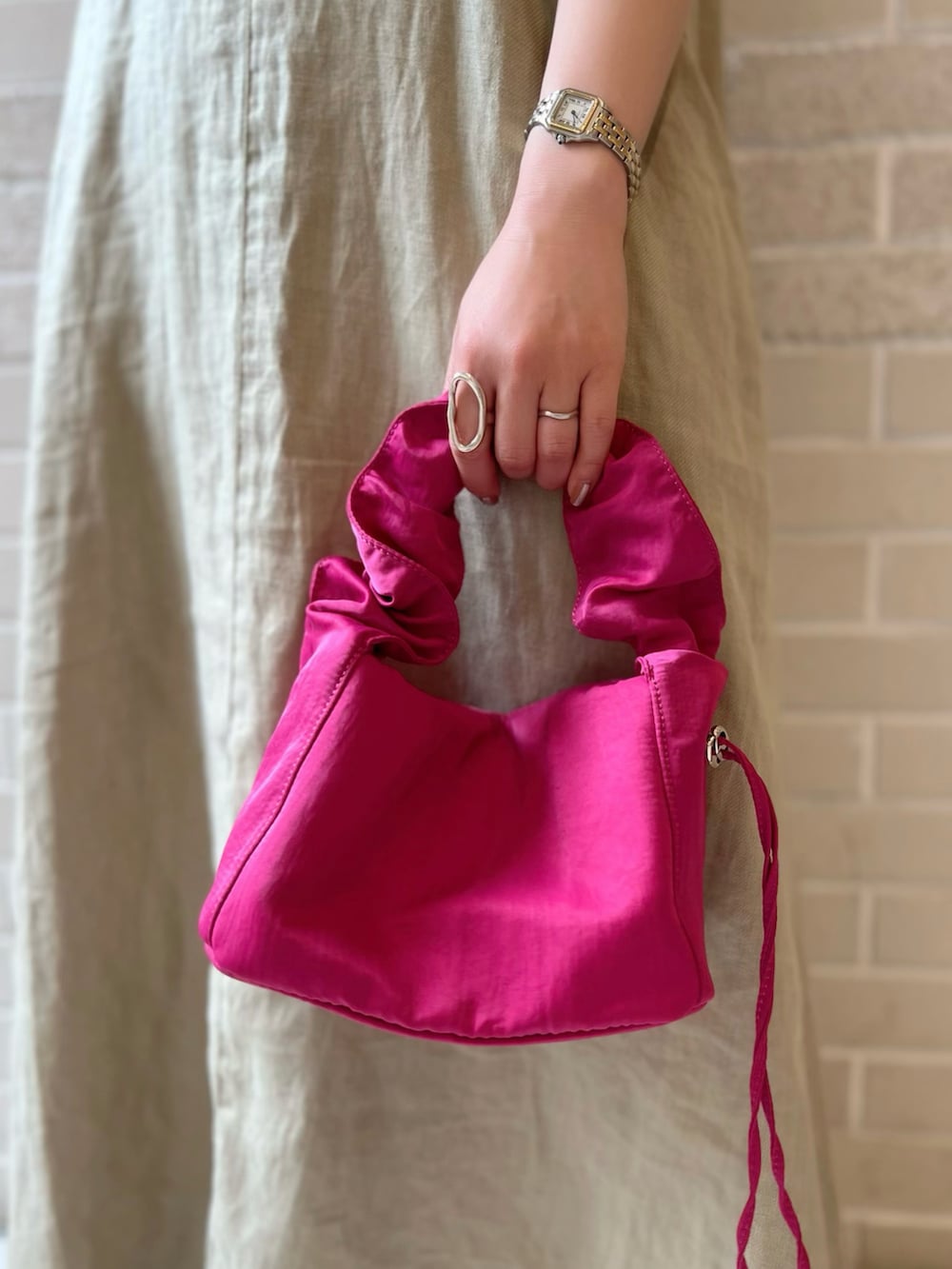 グリーン系のワンピース、ピンク系のハンドバッグ、ブラック系のサンダルを着用したレディースの夏コーディネートの5枚目の写真