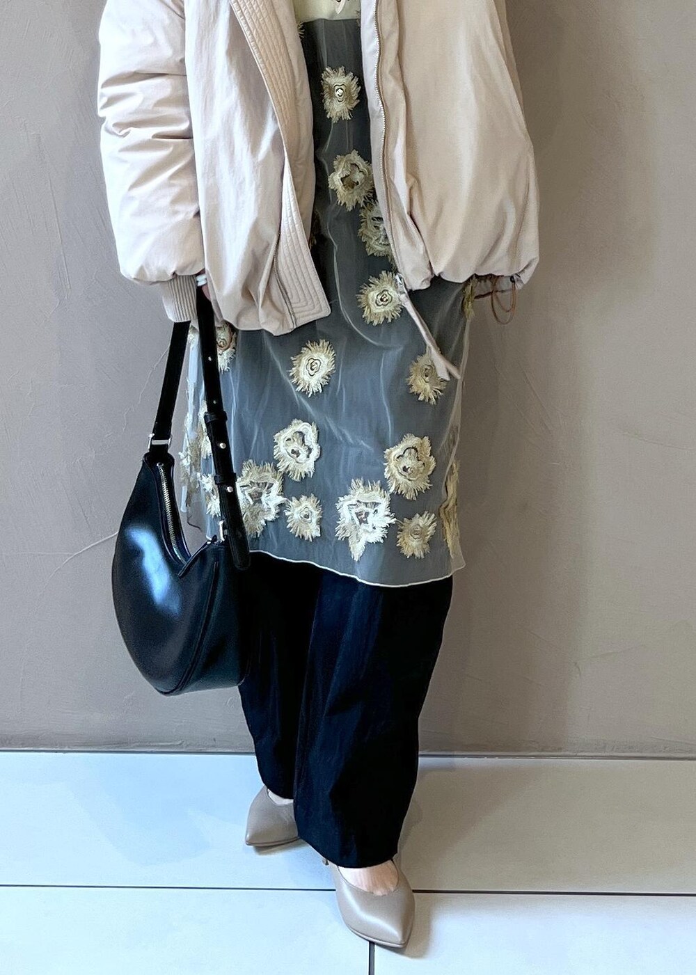 ゴールド系のワンピース、ベージュ系のダウンジャケット/コート、ホワイト系のTシャツ/カットソーを着用したレディースの秋コーディネートの7枚目の写真