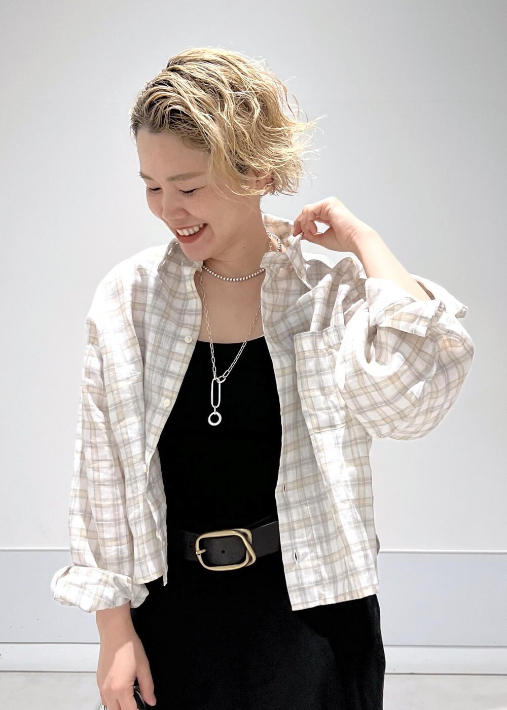 シルバー系のハンドバッグ、ホワイト系のサンダル、ブラック系のスカートを着用したレディースの春コーディネートの4枚目の写真