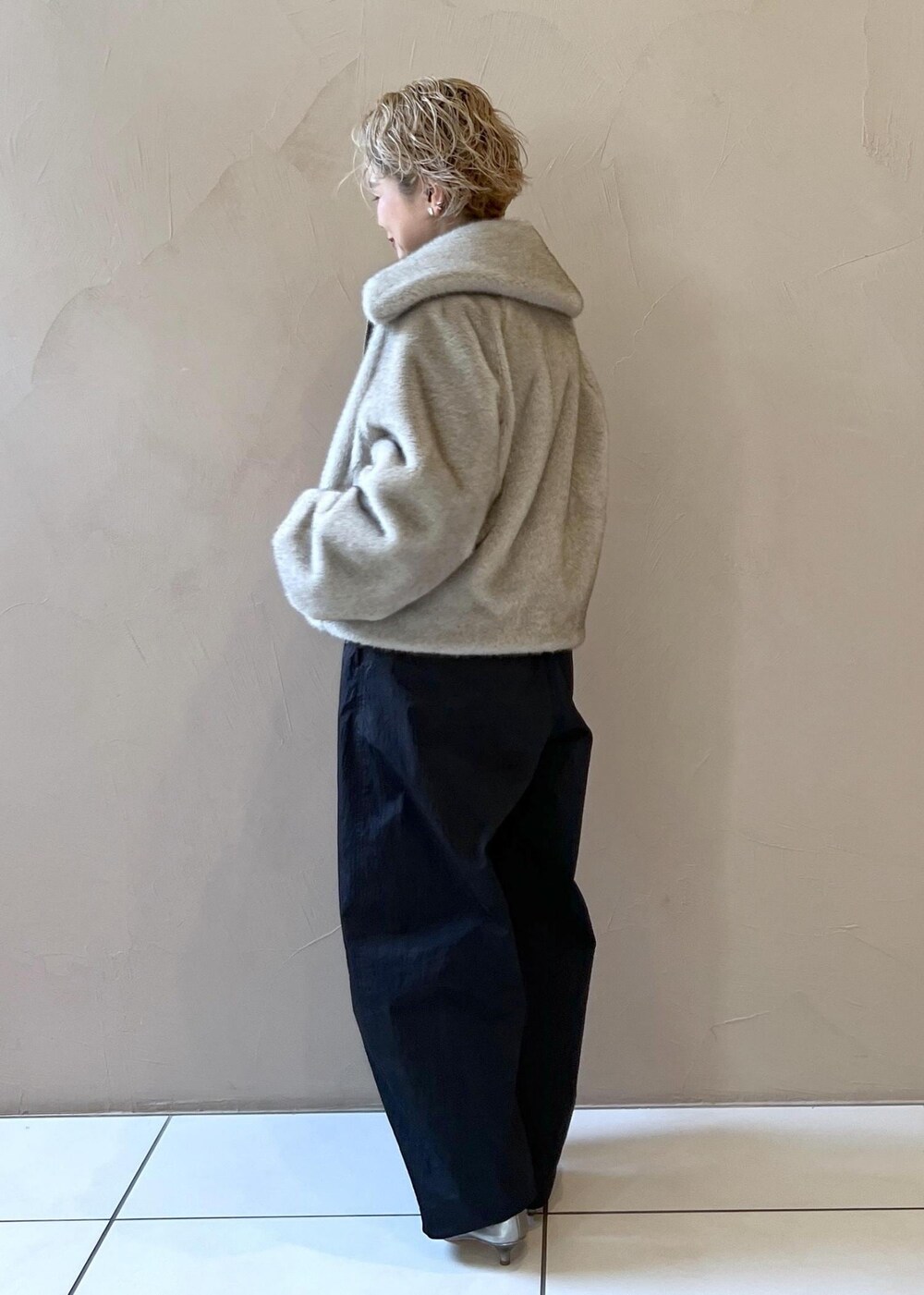 シルバー系のベスト、グレー系のブルゾン、グレー系のニット/セーターを着用したレディースの秋コーディネートの7枚目の写真