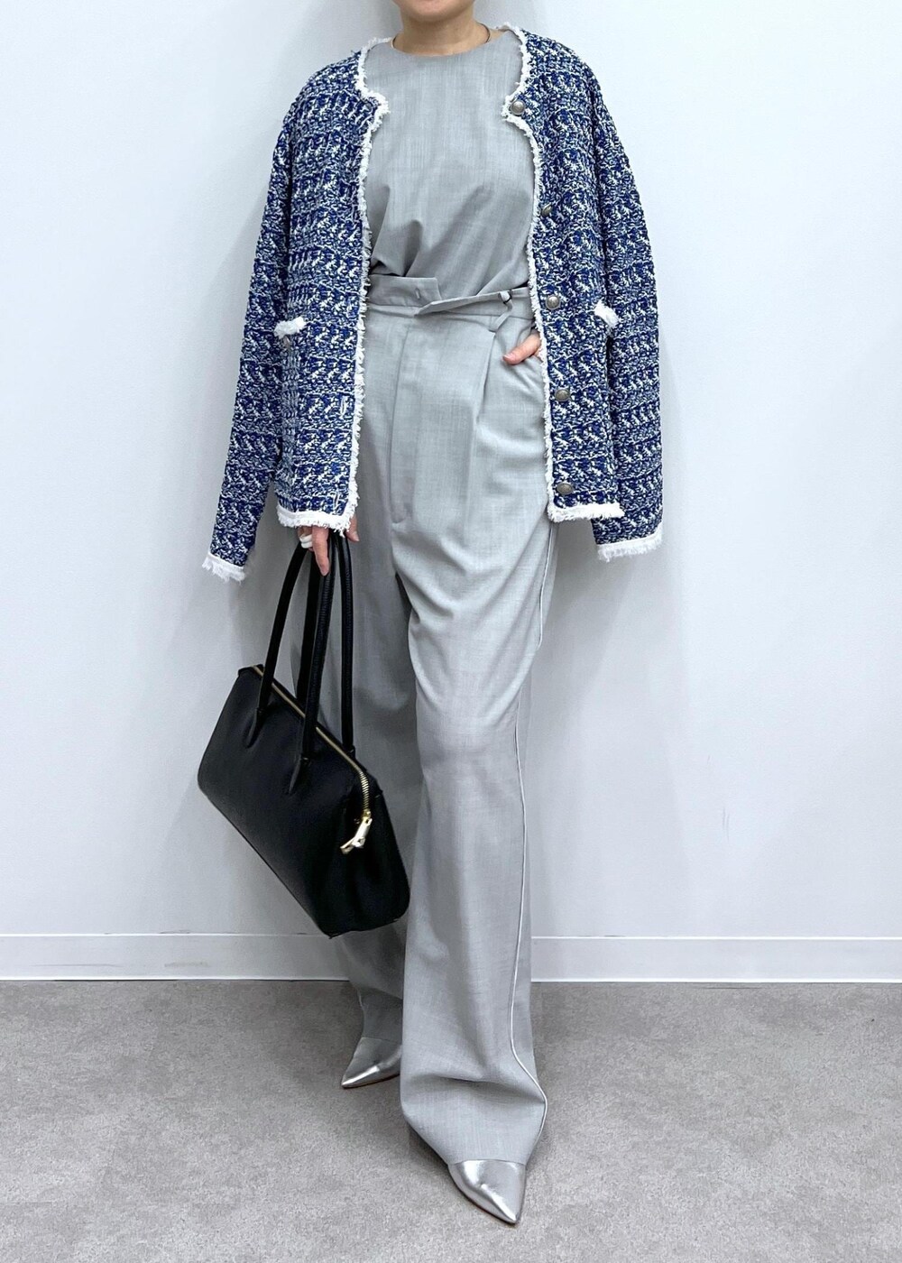 グレー系のベスト、グレー系のスラックス、シルバー系のパンプスを着用したレディースの春コーディネートの8枚目の写真