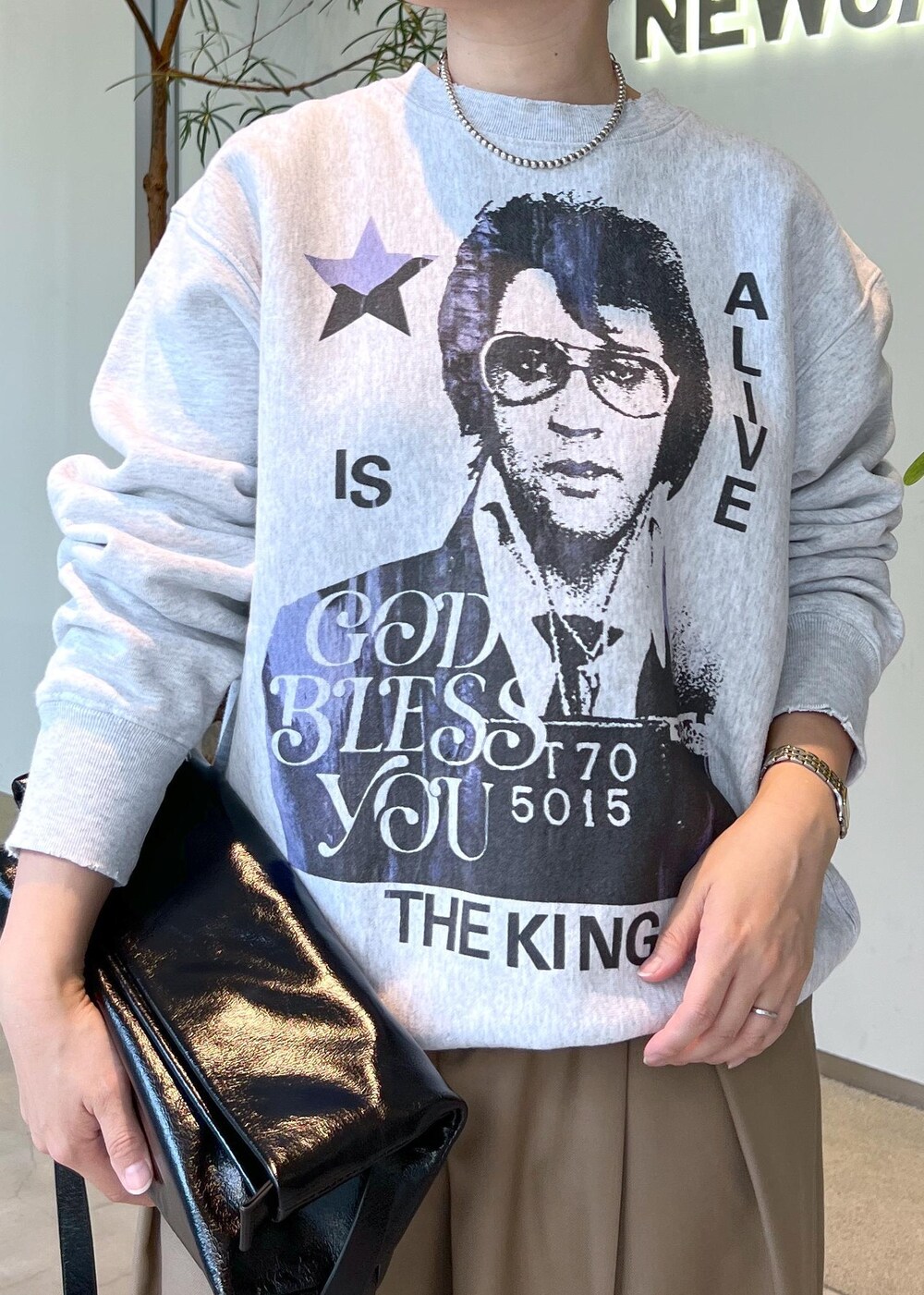 ベージュ系のスラックス、ブラック系のショルダーバッグ、ブラック系のスニーカーを着用したレディースの秋コーディネートの5枚目の写真