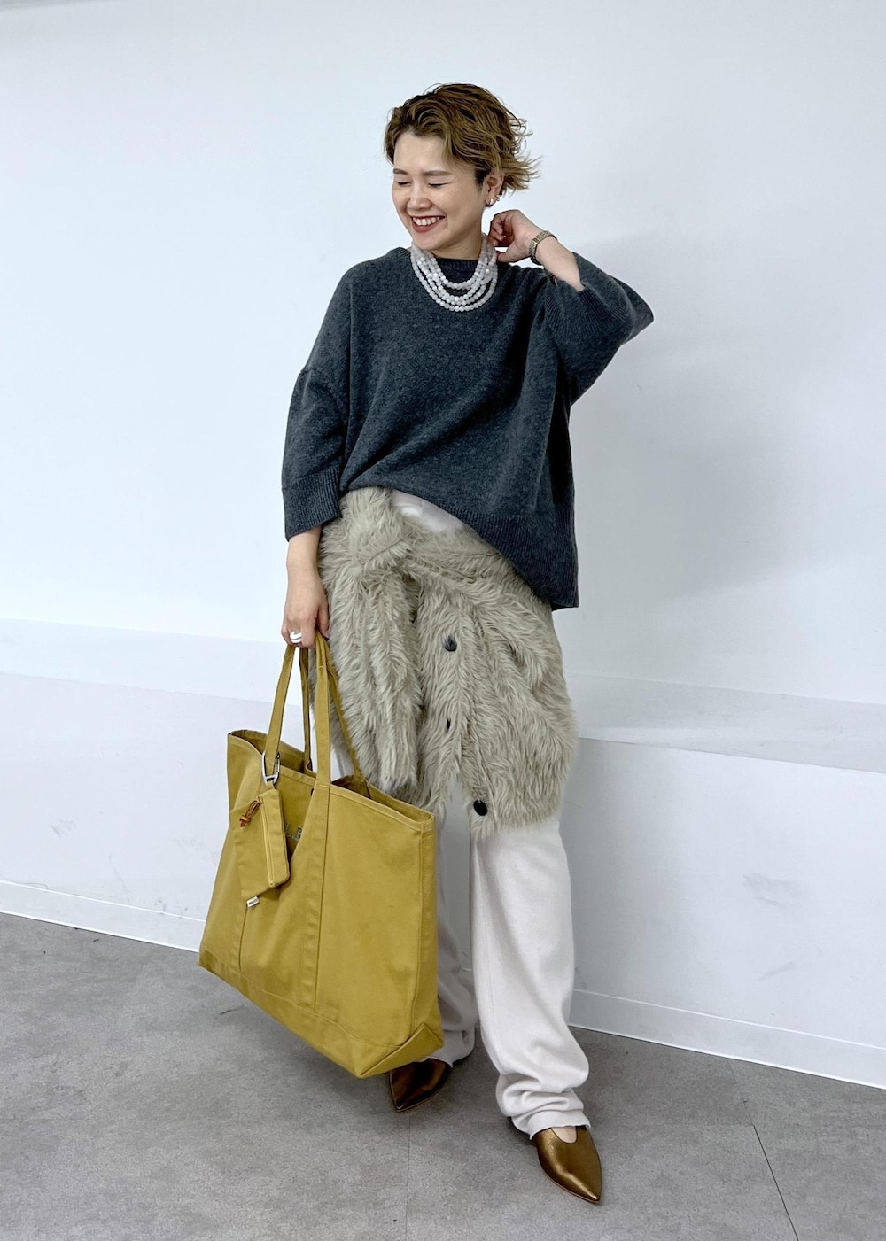 その他のパンプス、ベージュ系のカーディガン/ボレロ、ブラウン系のトートバッグを着用したレディースの秋コーディネートの2枚目の写真