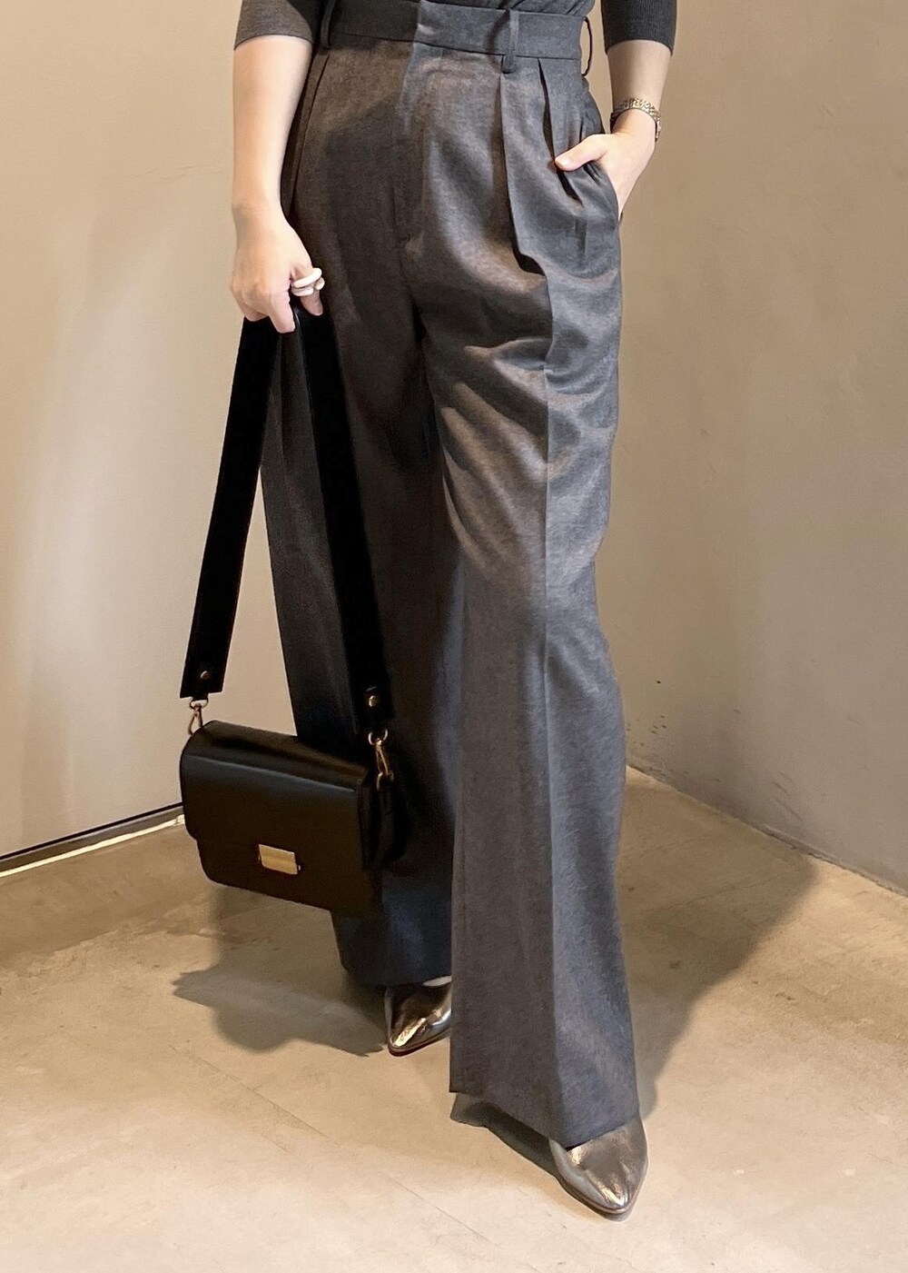 ブラック系のショルダーバッグ、グレー系のニット/セーター、グレー系のスラックスを着用したレディースの秋コーディネートの7枚目の写真